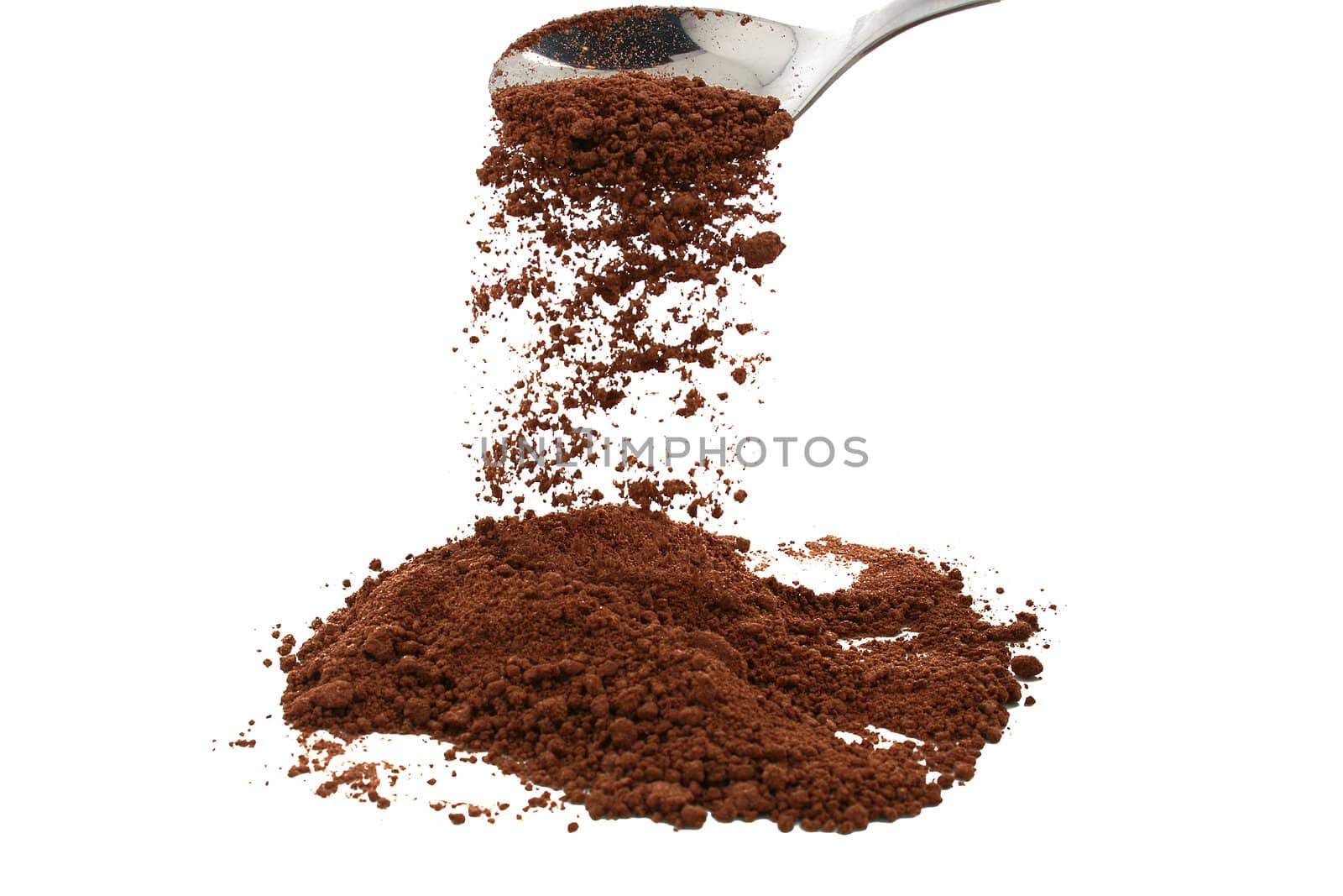 cocoa powder trickling from silver spoon