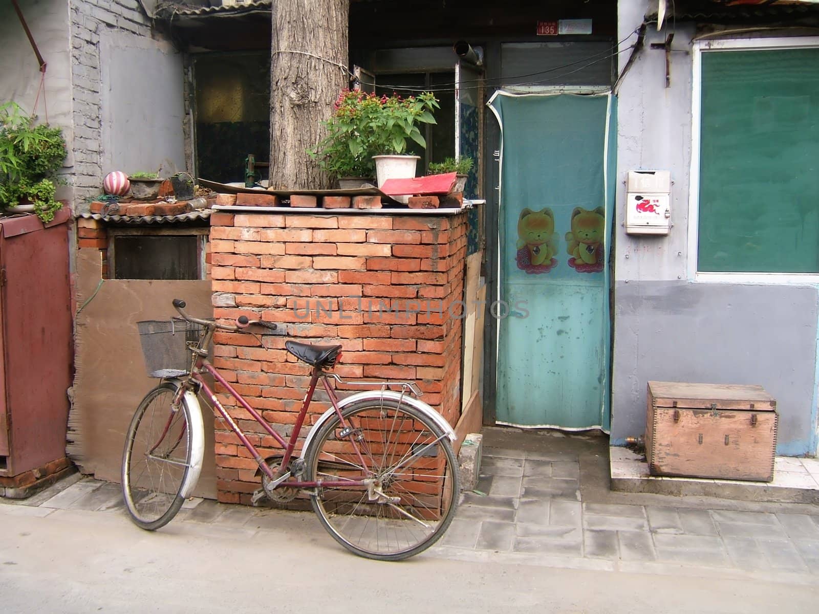 Bicycle in front of a house in a hutong (traditional ancient downtown quarter) in Beijing (Peking)