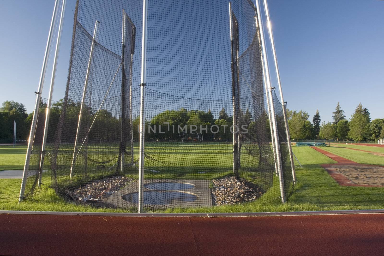 athletic field with a hammer throw cage and long jump sand pit by PixelsAway