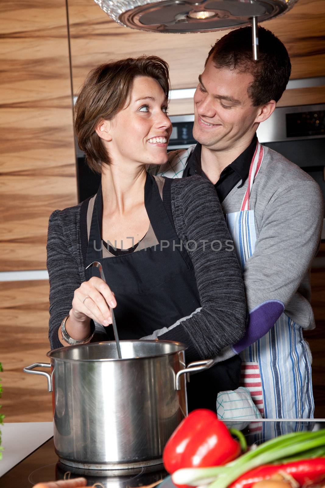 Happy young couple cooking together in the kitchen