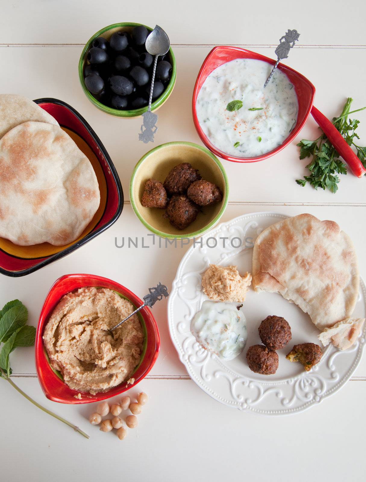 Delicious table filled with snack such as homemade pita, tzatziki, hummus and falafel