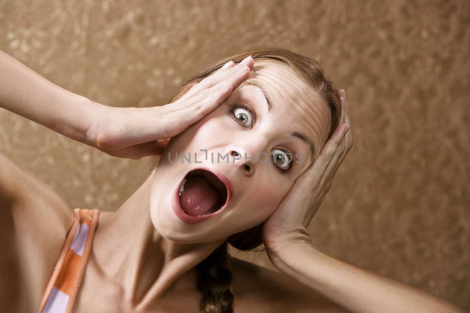 Horrified Young Woman in front of Gold wallpaper