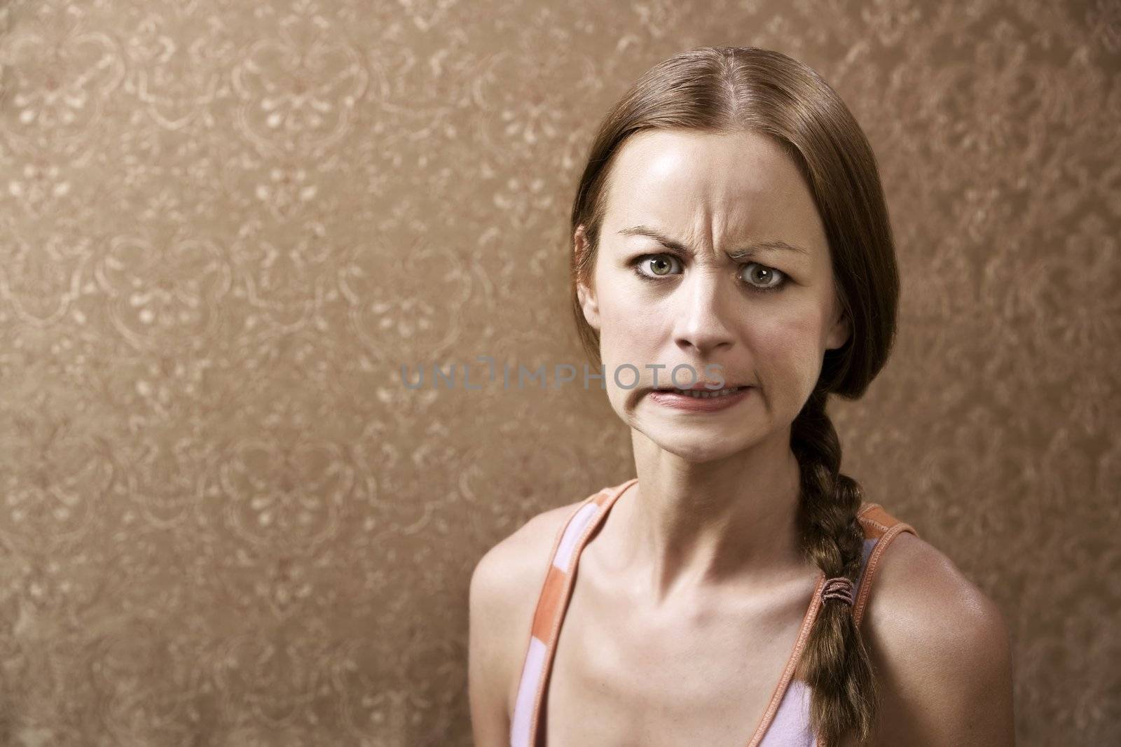 Angry Young Woman in front of Gold wallpaper
