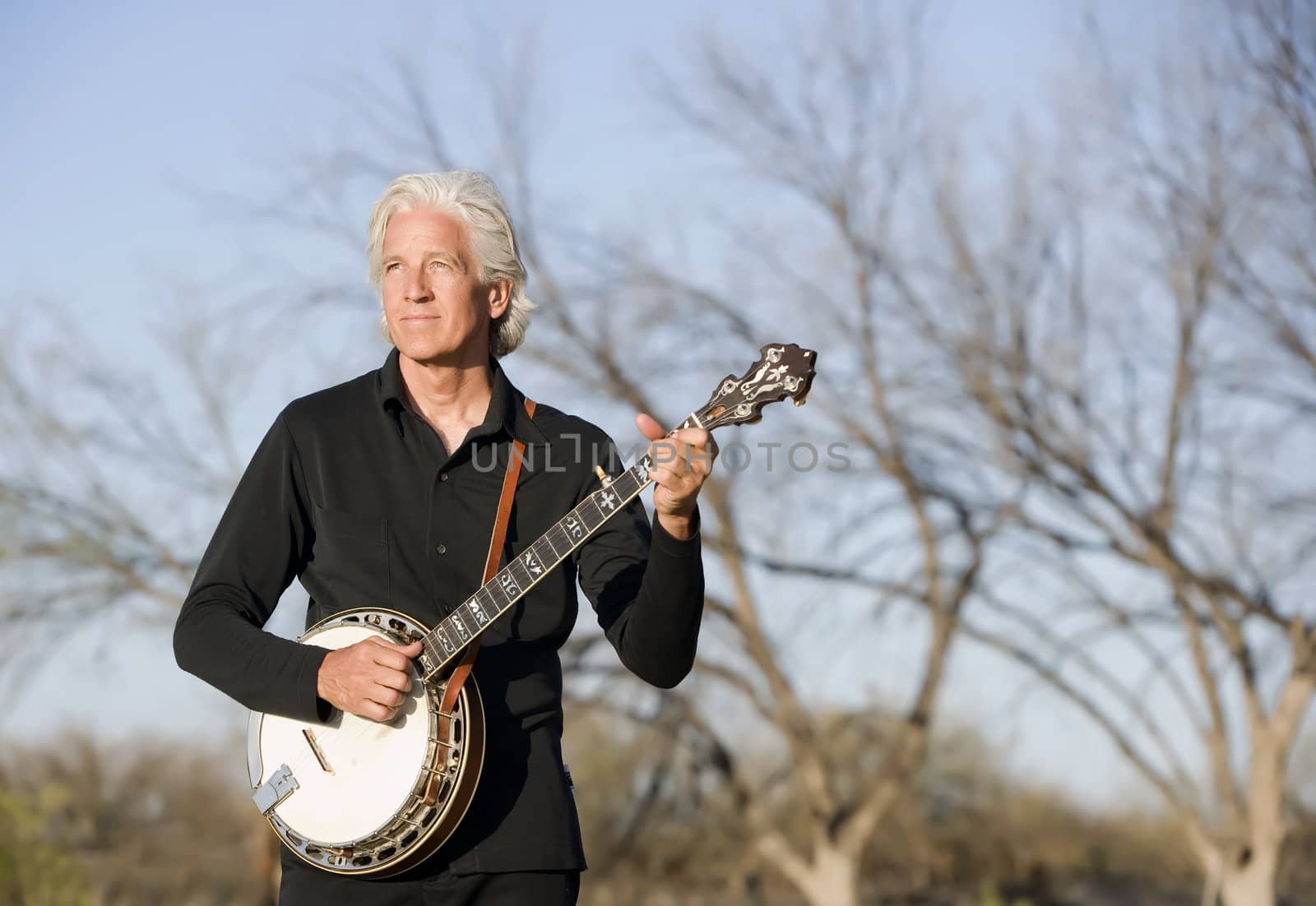 Banjo Player in Front of a Bare Trees