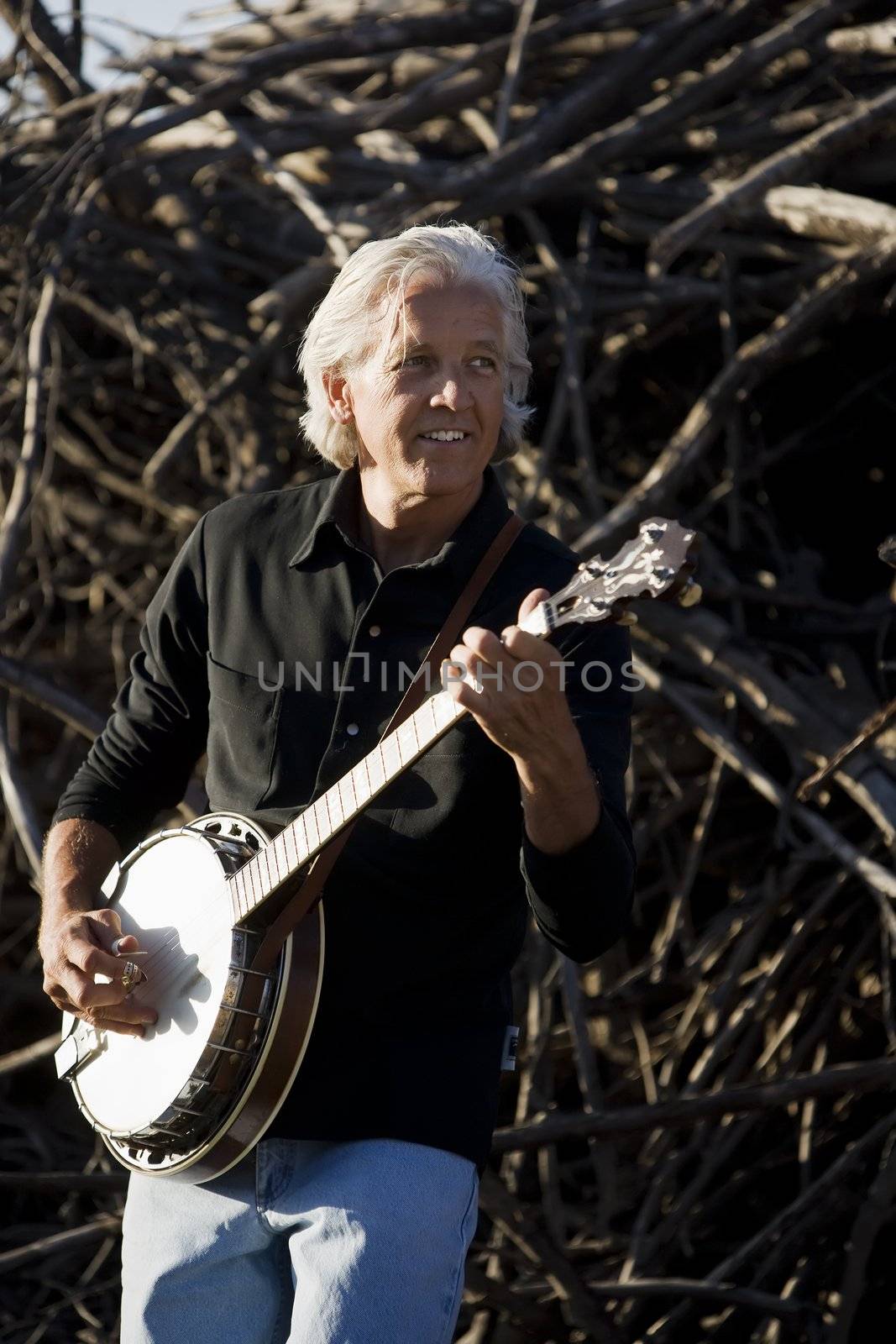 Banjo Player in Front of a Big Pile of Wood