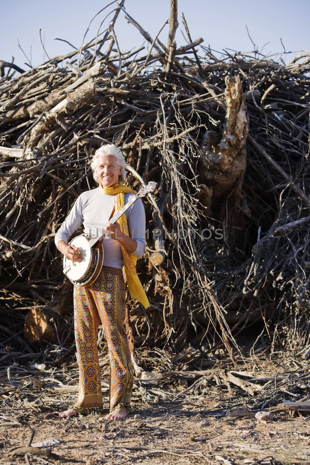 Barefoot banjo Player in Front of a Big Pile of Wood