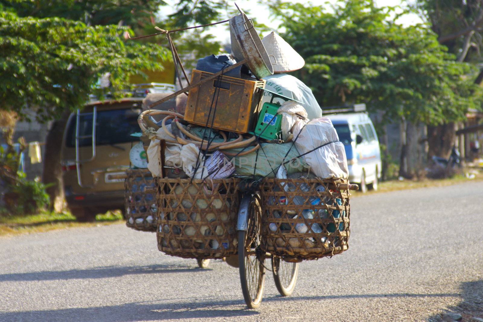 Asian man on a bicycle transporting his stuff