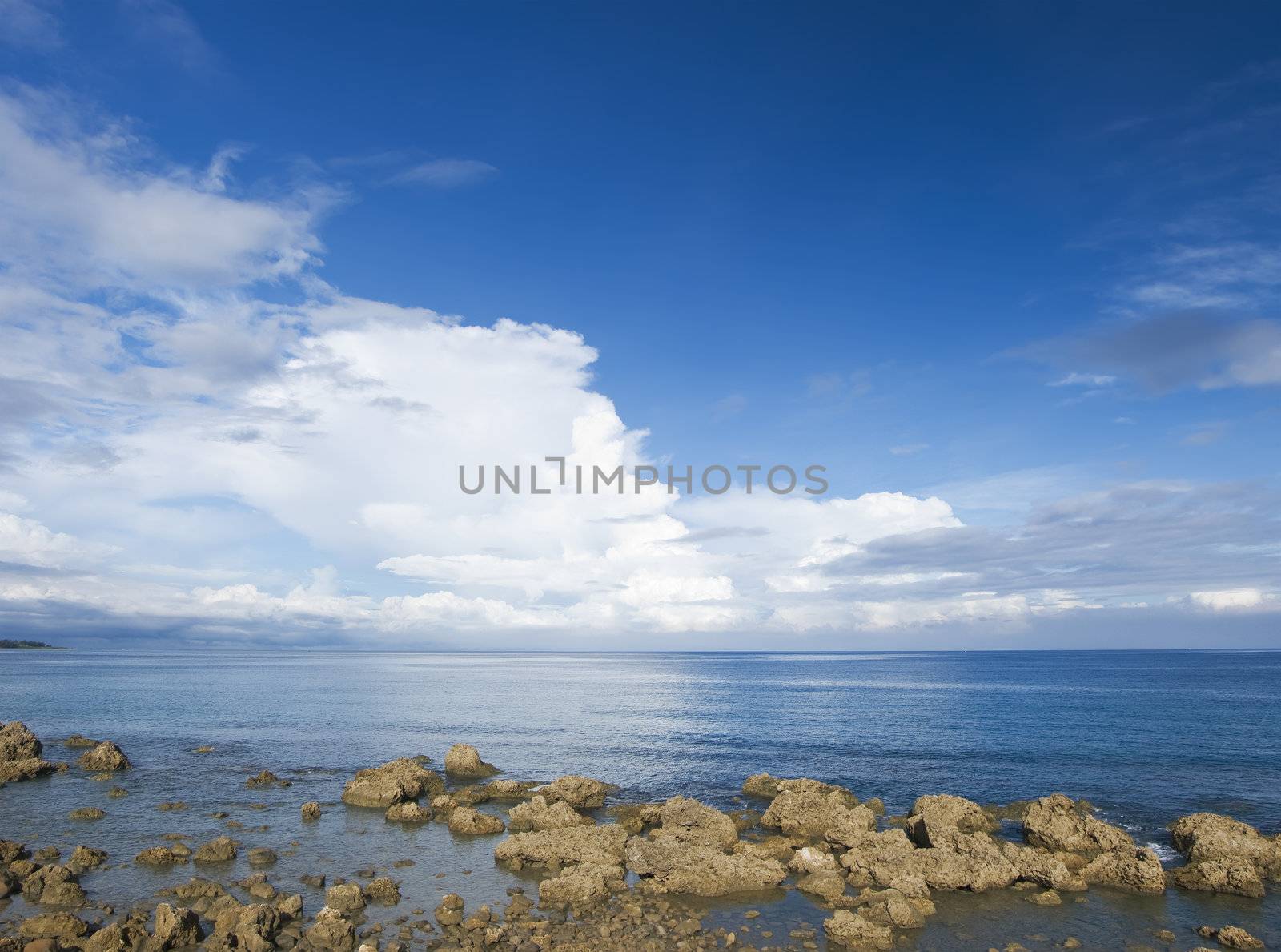 Beach of coral reef rock coastline with blue sky.