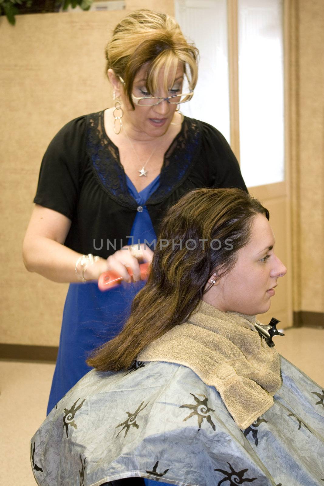 A hairdresser working on a client in the salon.  