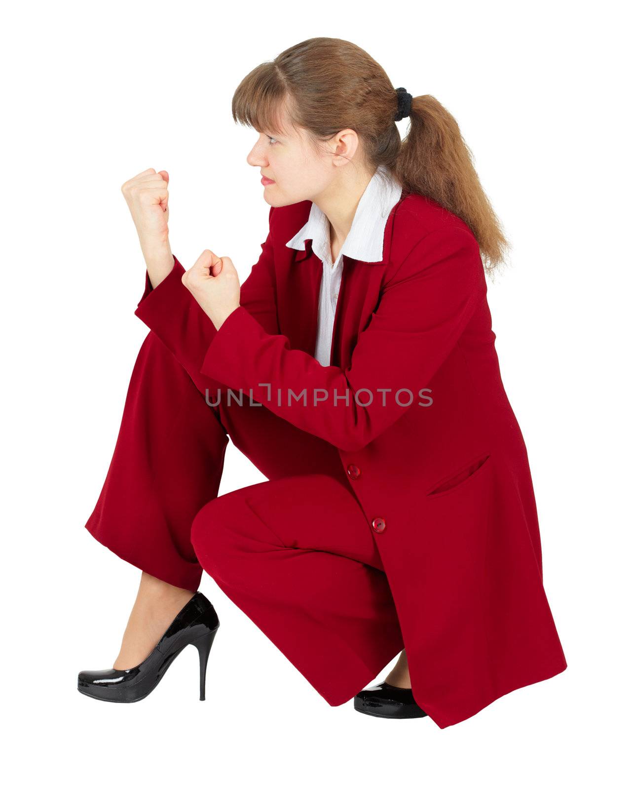 A woman in a red business suit sitting in a combat stance