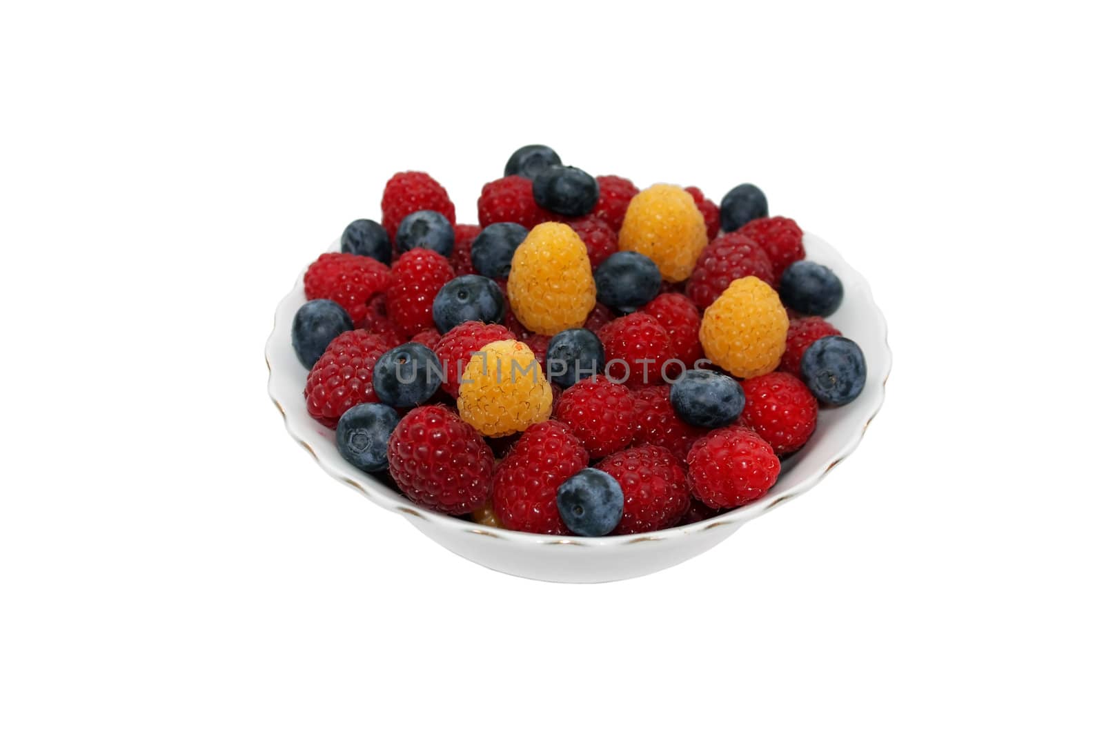 Red and yellow raspberries and blueberries in the bowl, isolated