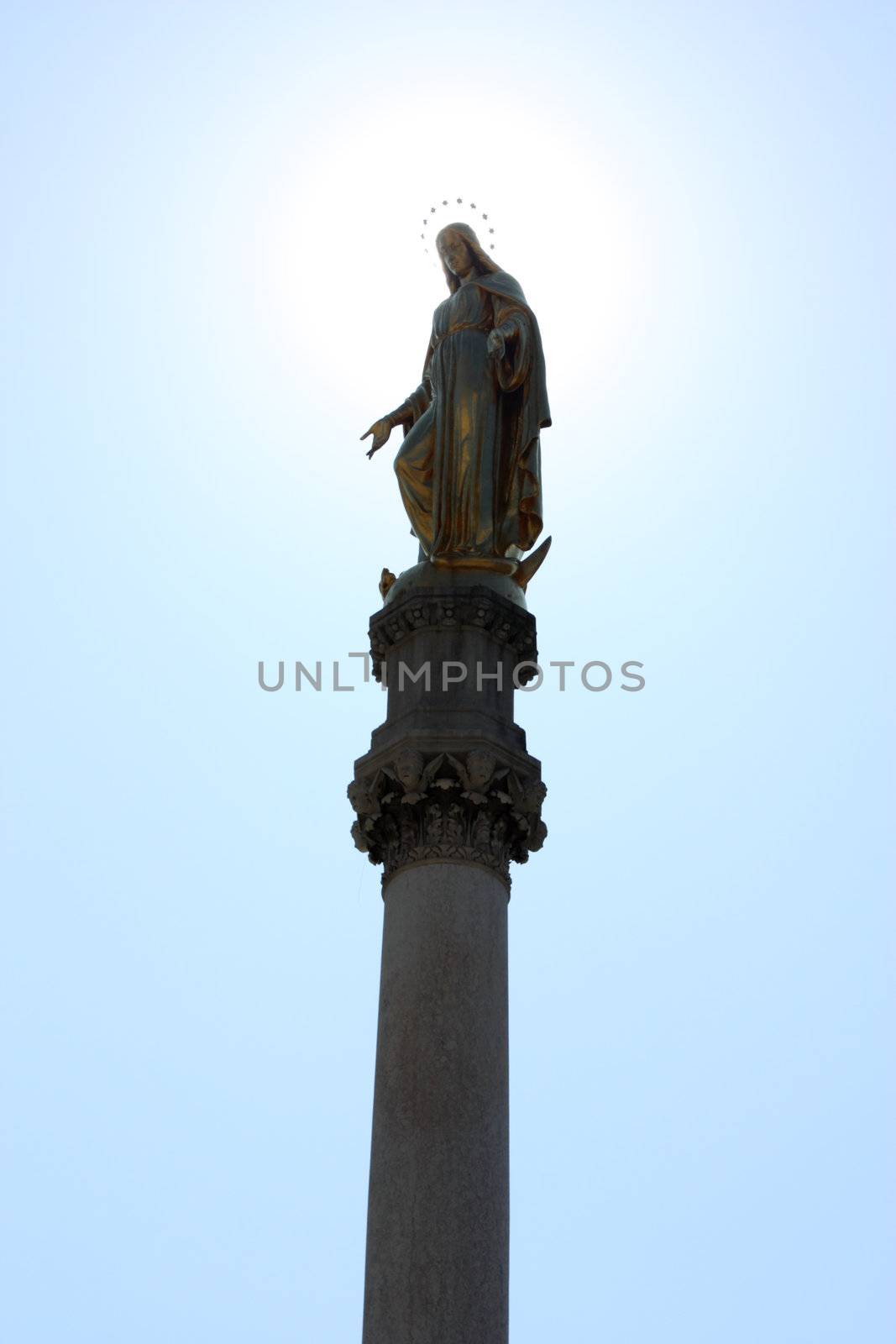 Statue of the Blessed Virgin Mary near cathedral in Zagreb, Croatia, with sun in background