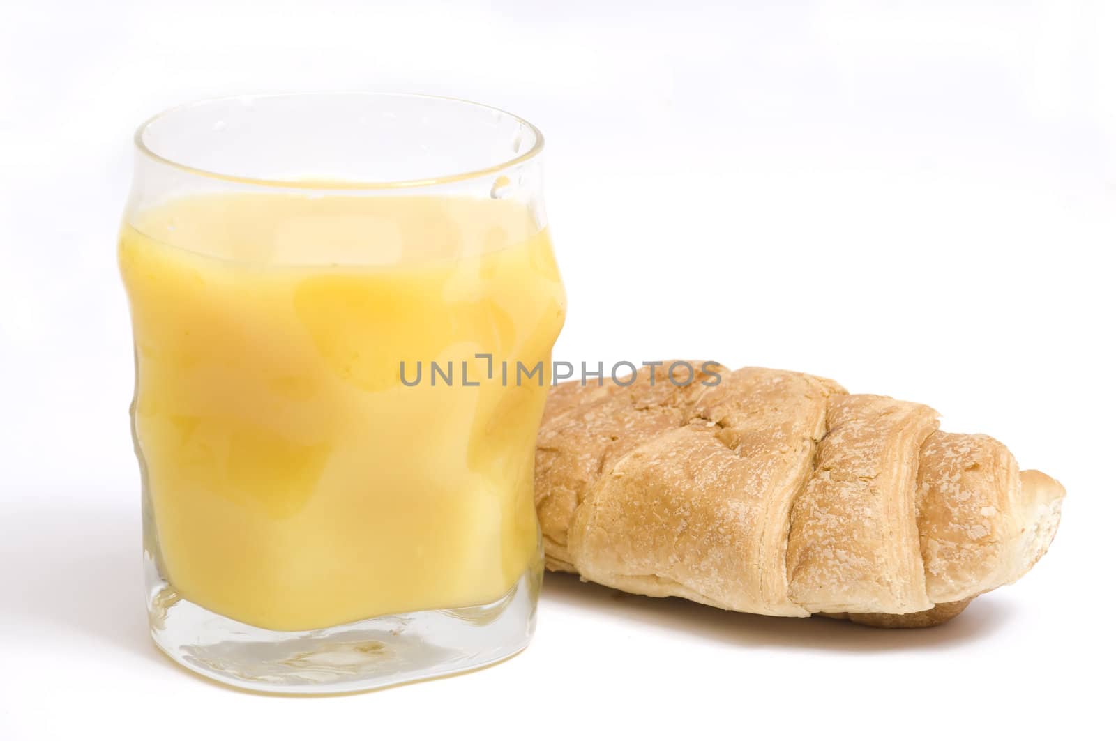 close up on orange juice glass and fresh croissant, isolated on white
