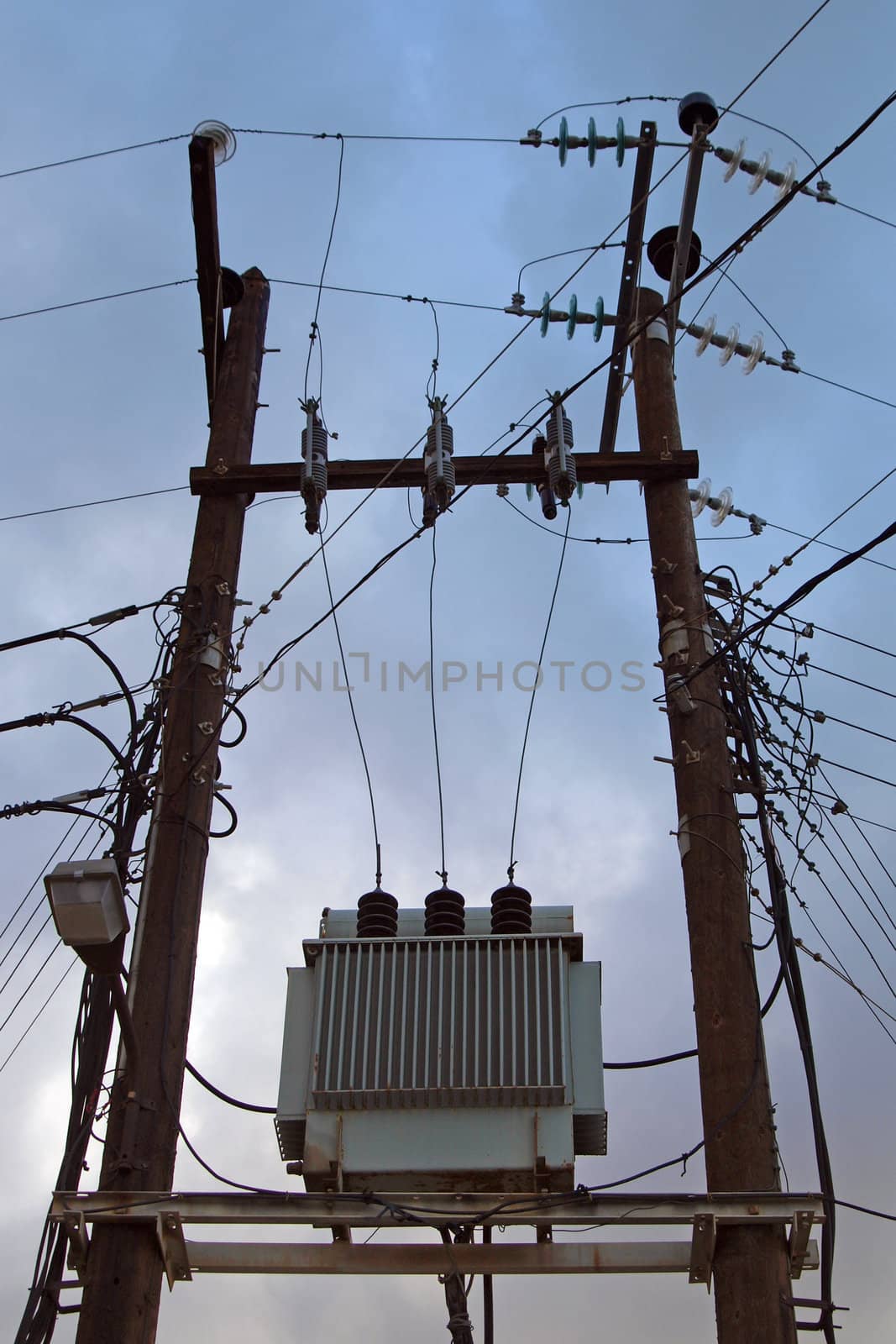 High voltage electricity transformer high on poles in England