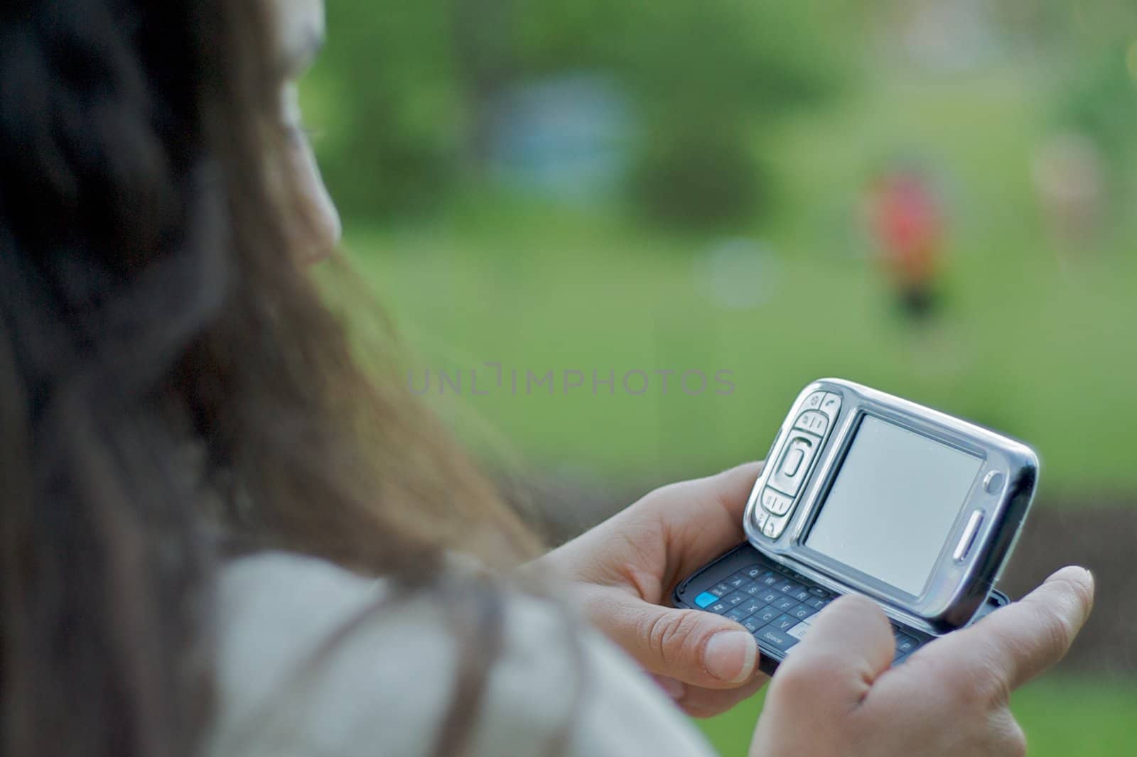 A young woman texting on a smart-phone with a fully QWERTY keyboard