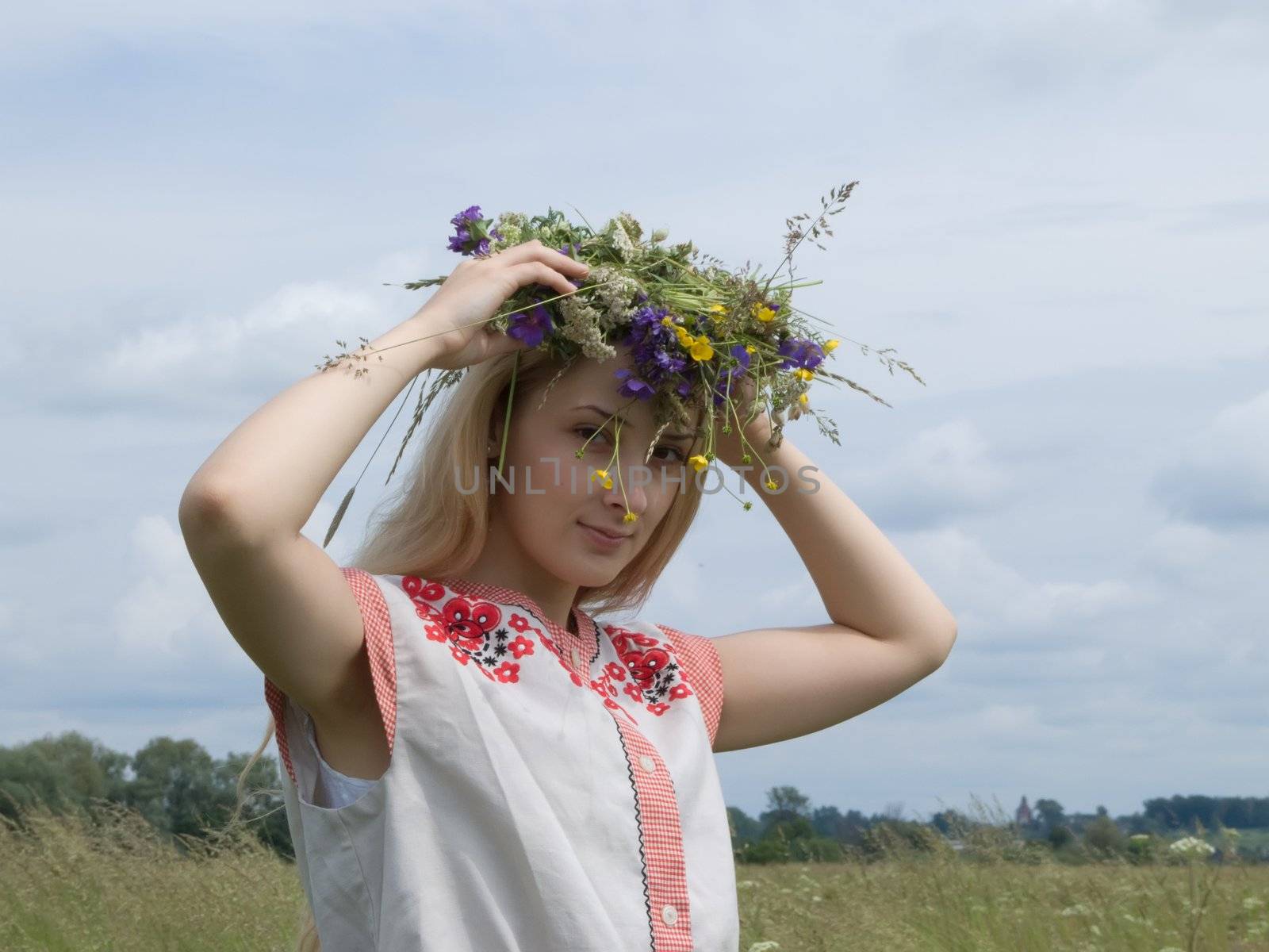 girl in a chaplet from meadow flowers
and clothing of russian woman of XV age