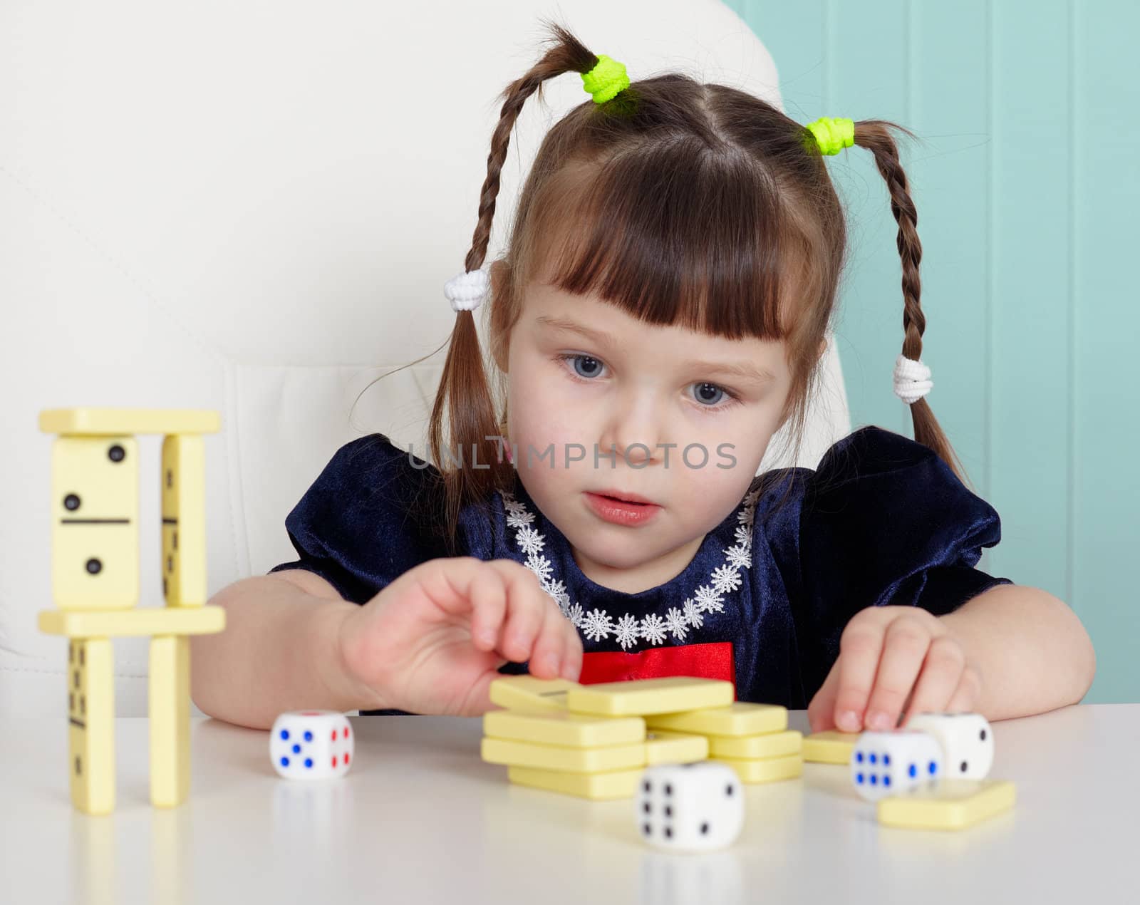 A child playing with small toys, sitting at the table