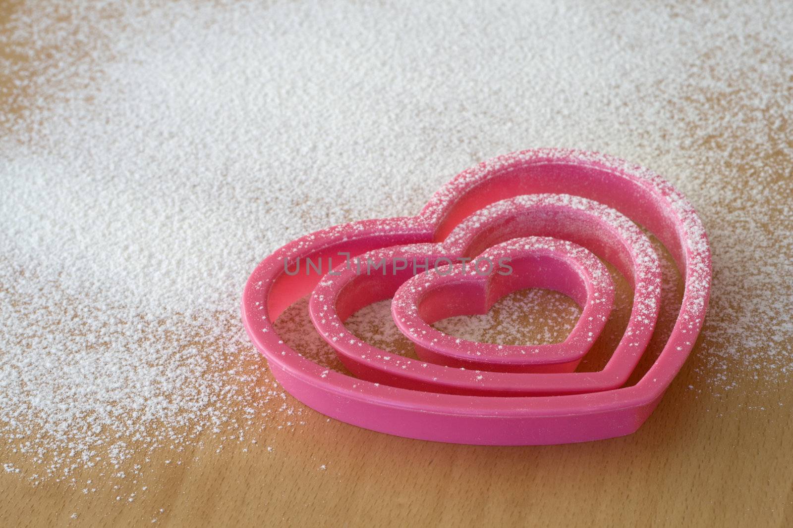 Pink cookie cutters on a wooden table