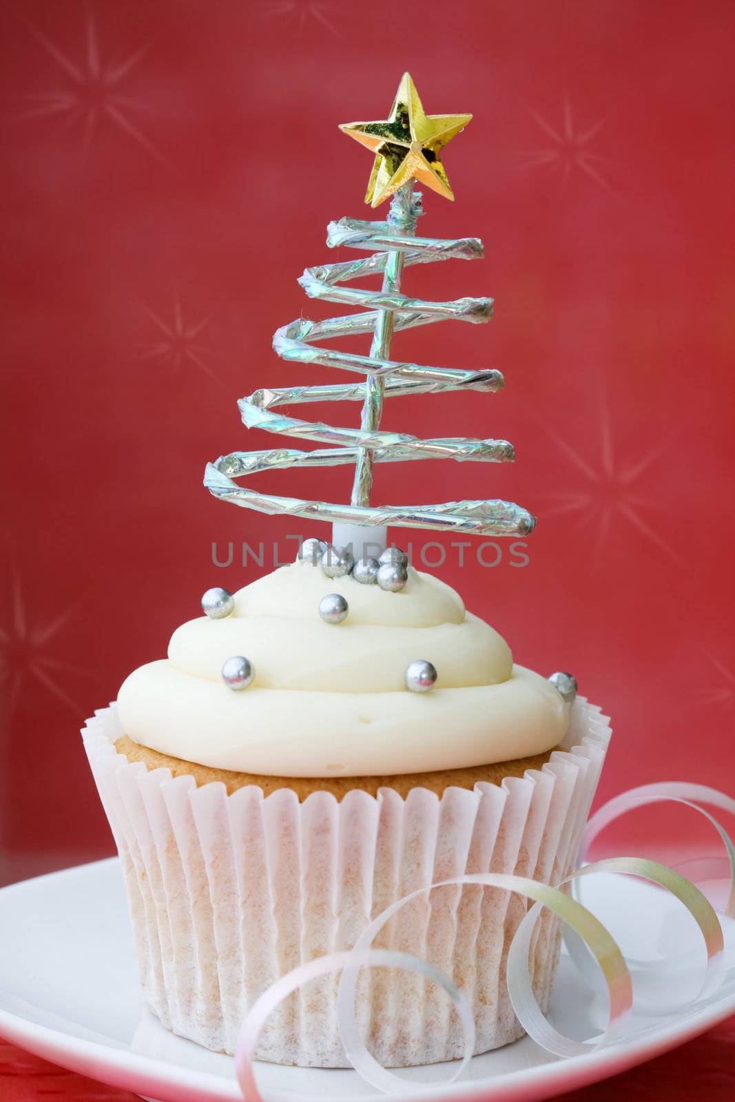 Cupcake decorated with silver dragees and a spiral Christmas tree