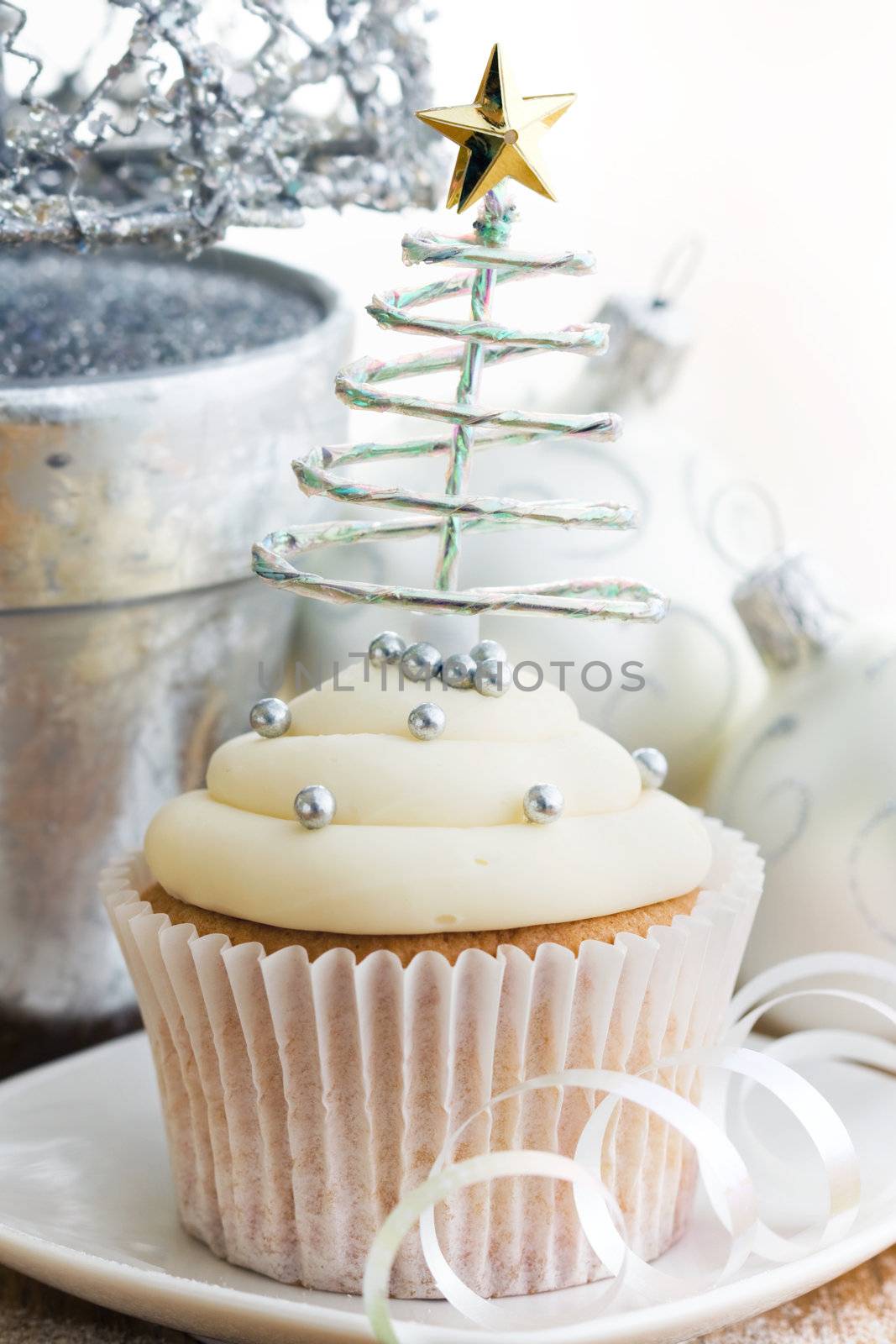 Cupcake decorated with silver dragees and a spiral Christmas tree