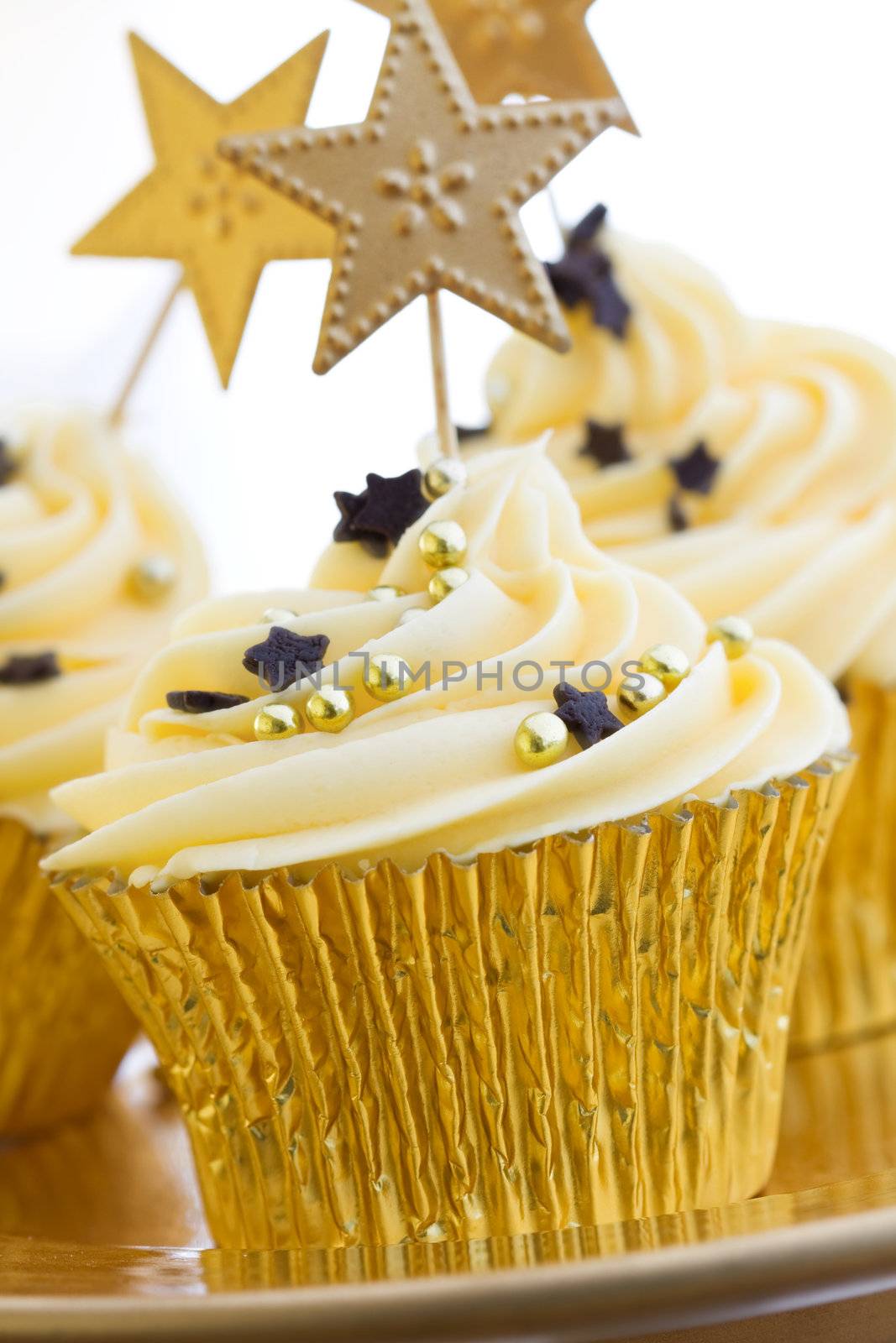 Cupcakes decorated with chocolate stars and golden dragees