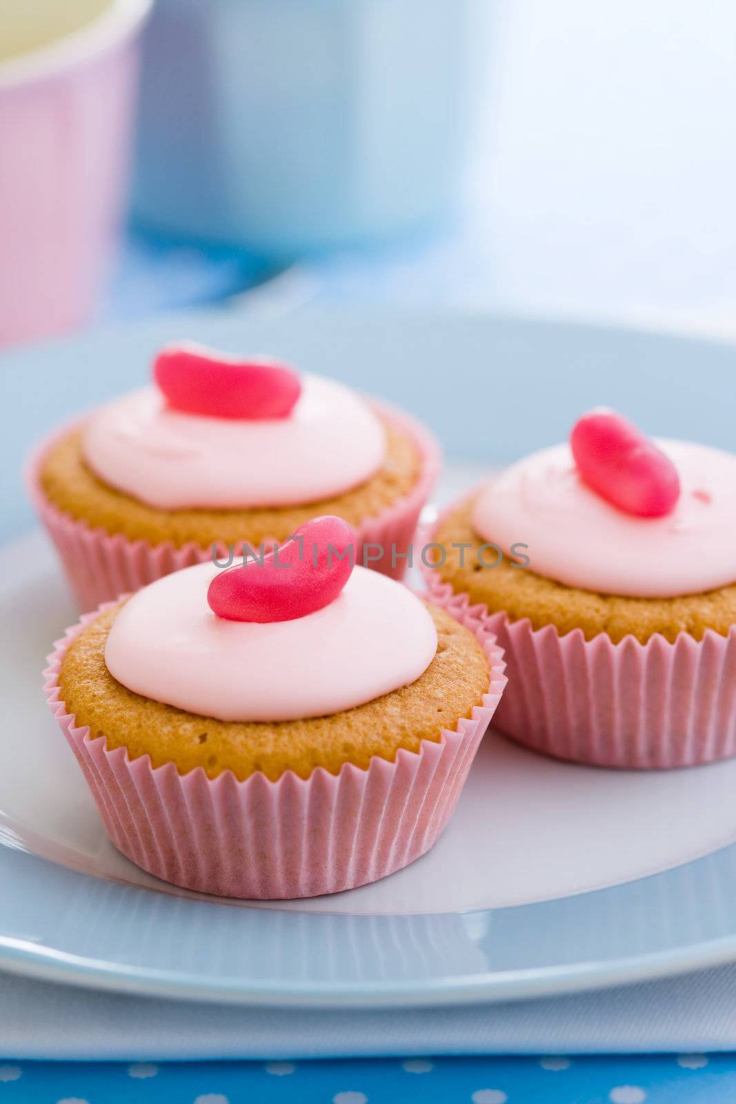 Three pink cupcakes decorated with jelly beans