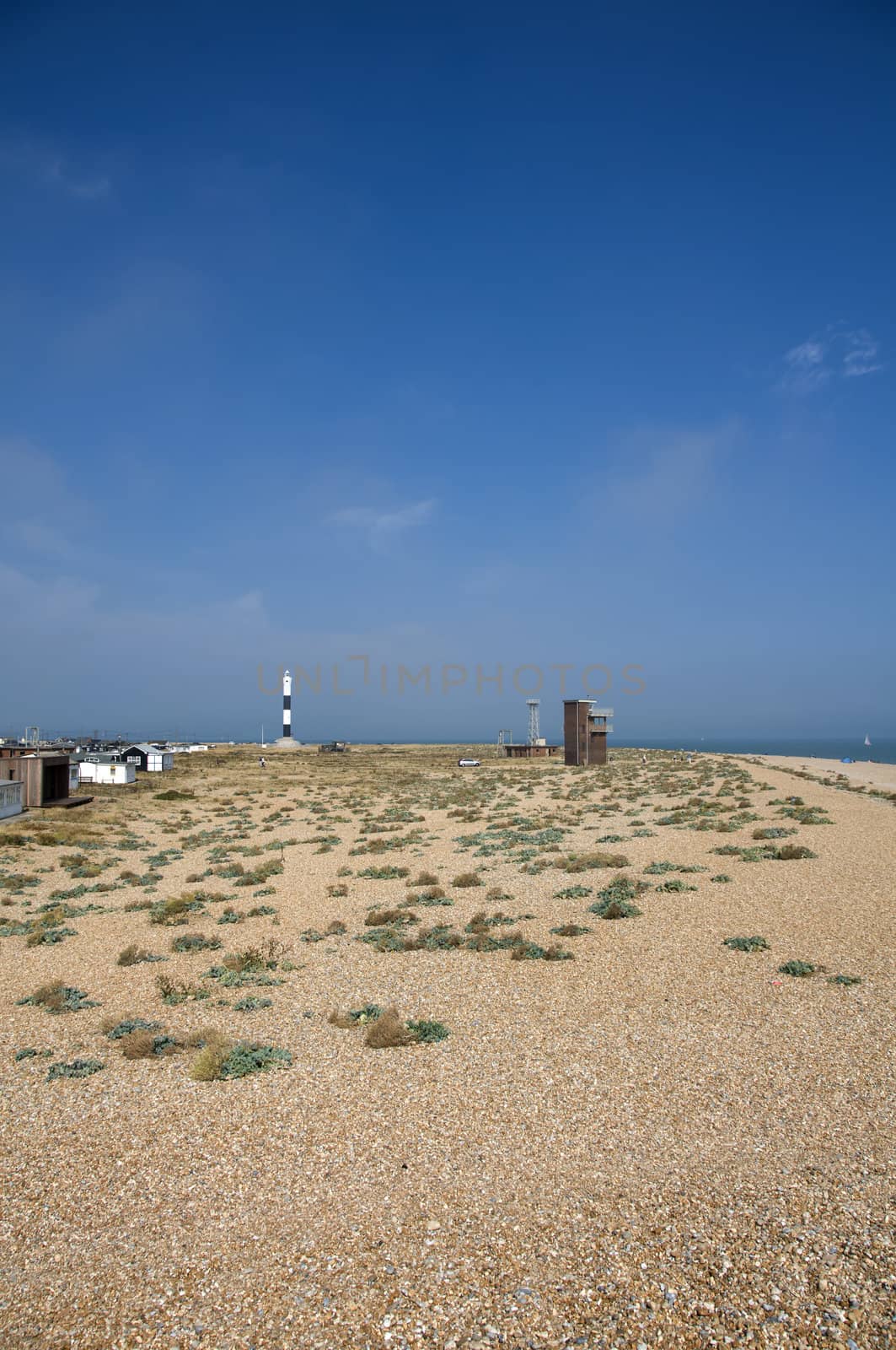 The pebble beach at Dungeness with the new lighthouse in the distance