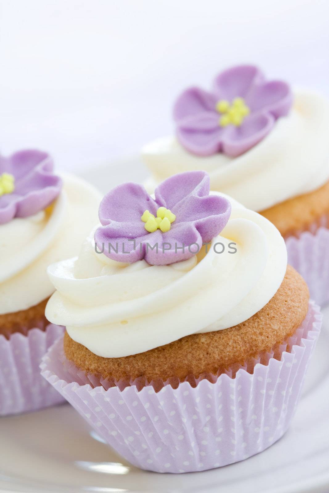 Mini cupcakes decorated with purple sugar flowers