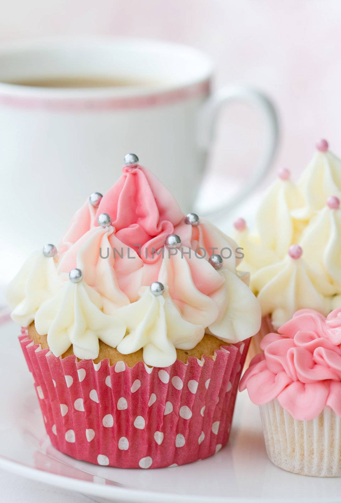 Selection of delicious cupcakes served with a cup of tea