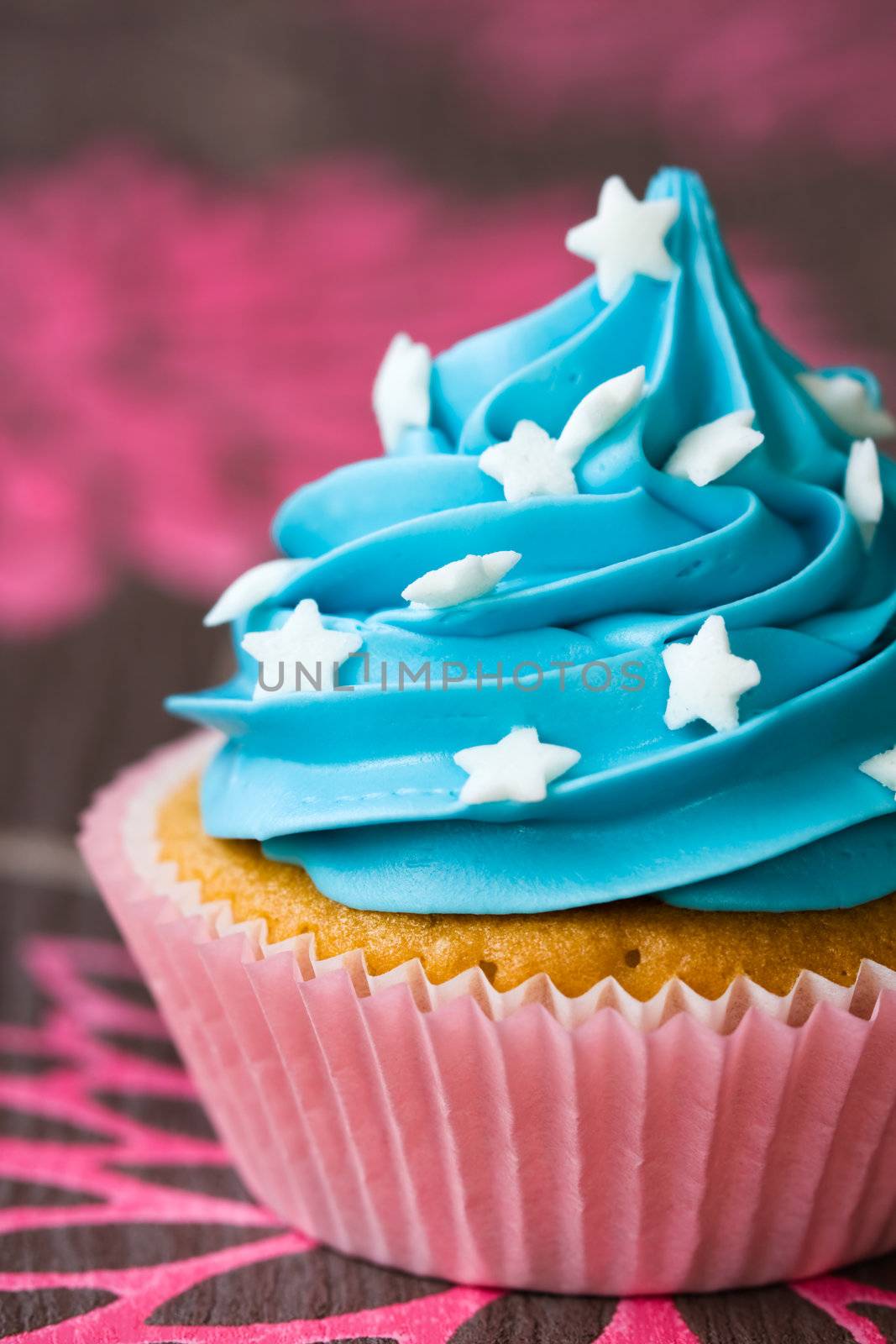 Blue and pink cupcake decorated with white sugar stars