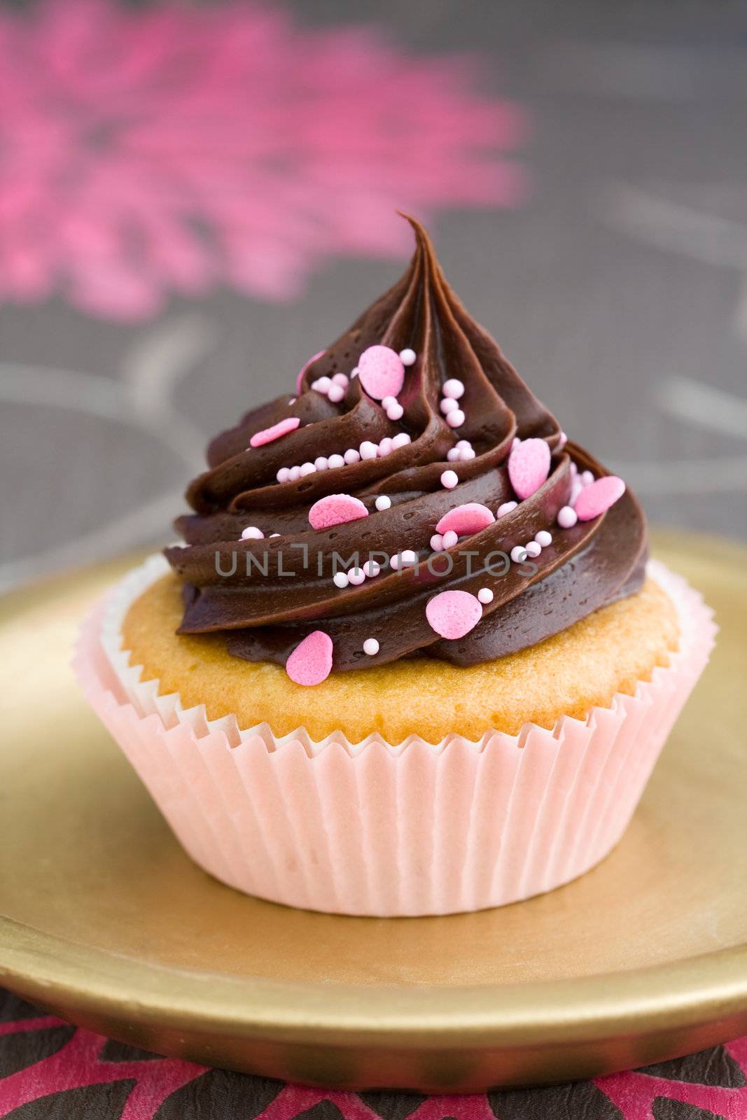 Pink chocolate cupcake served on a gold plate
