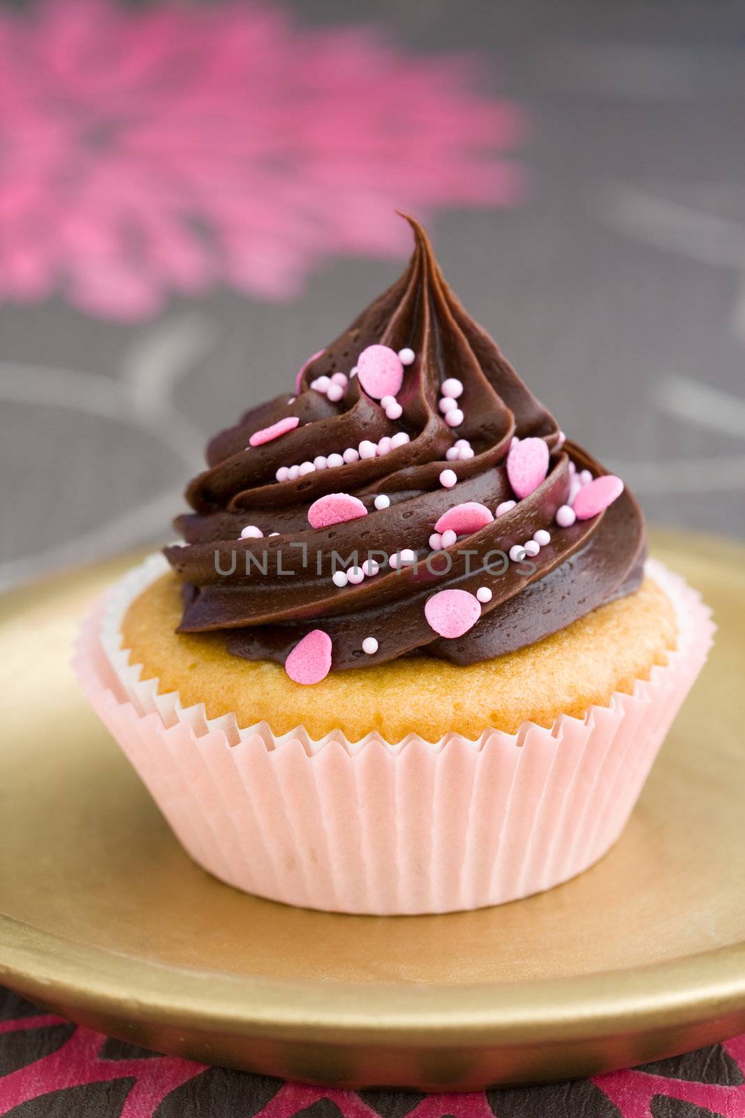 Pink chocolate cupcake served on a gold plate
