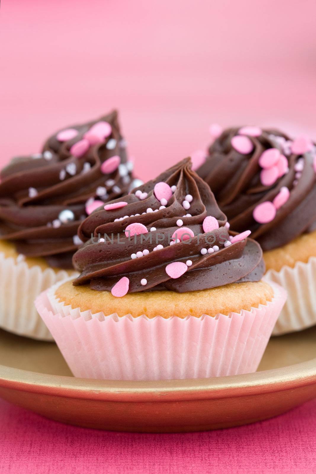 Trio of pink chocolate cupcakes on a plate