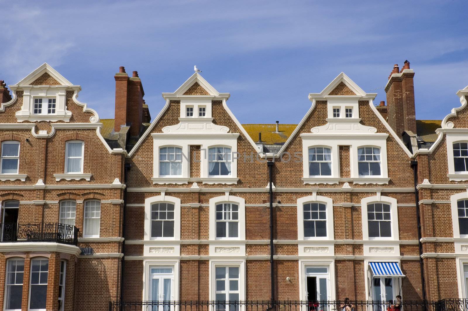 A row of victorian townhouses with a blue sky