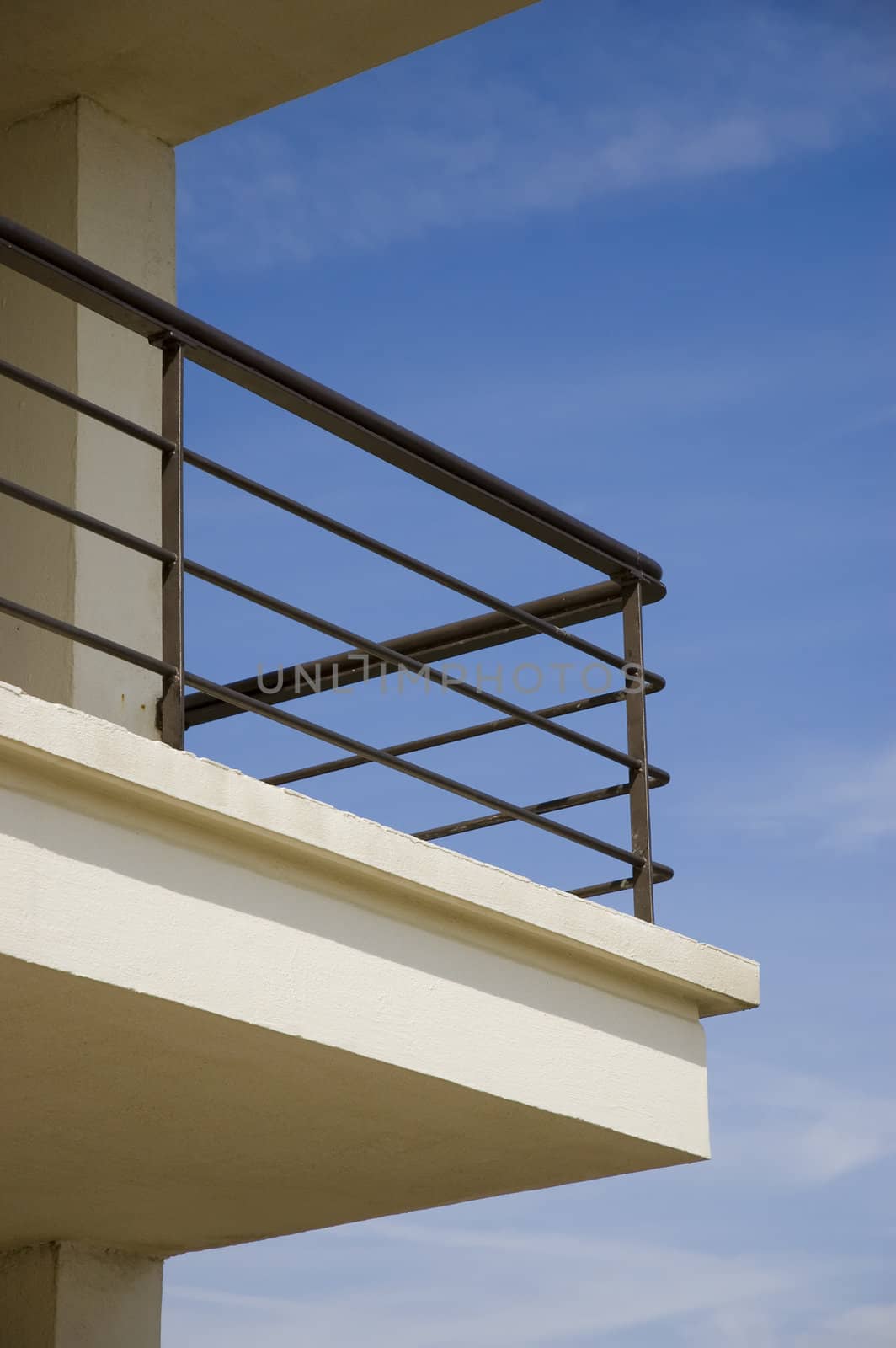 A balcony against a blue sky with some clouds