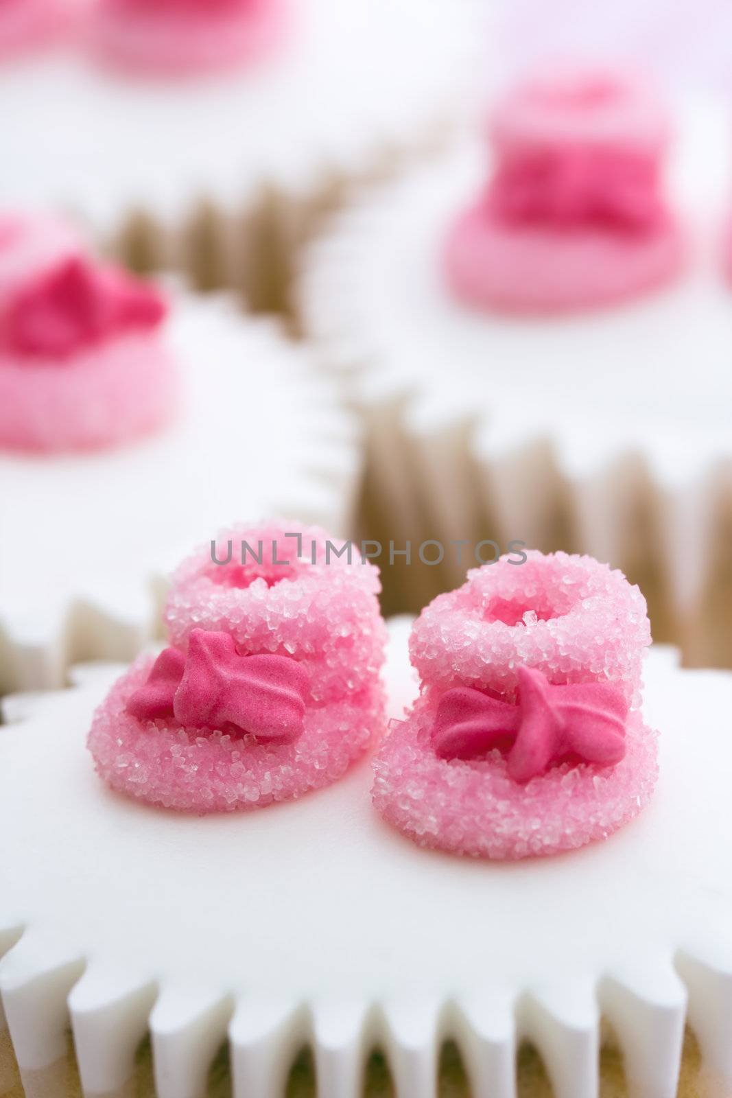 Cupcakes decorated with tiny pink sugar booties