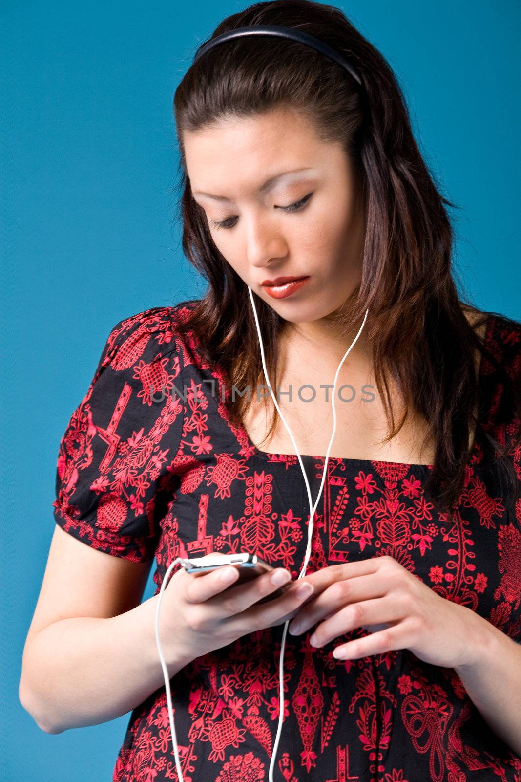 Young girl is busy with her mp3 player