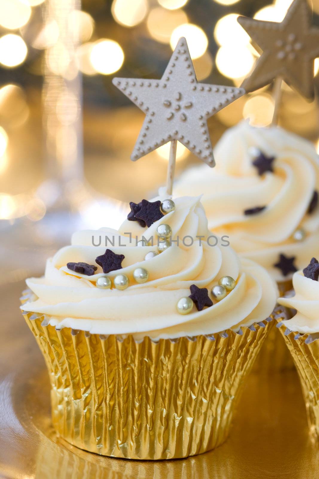 Golden cupcakes against a background of defocused fairy lights