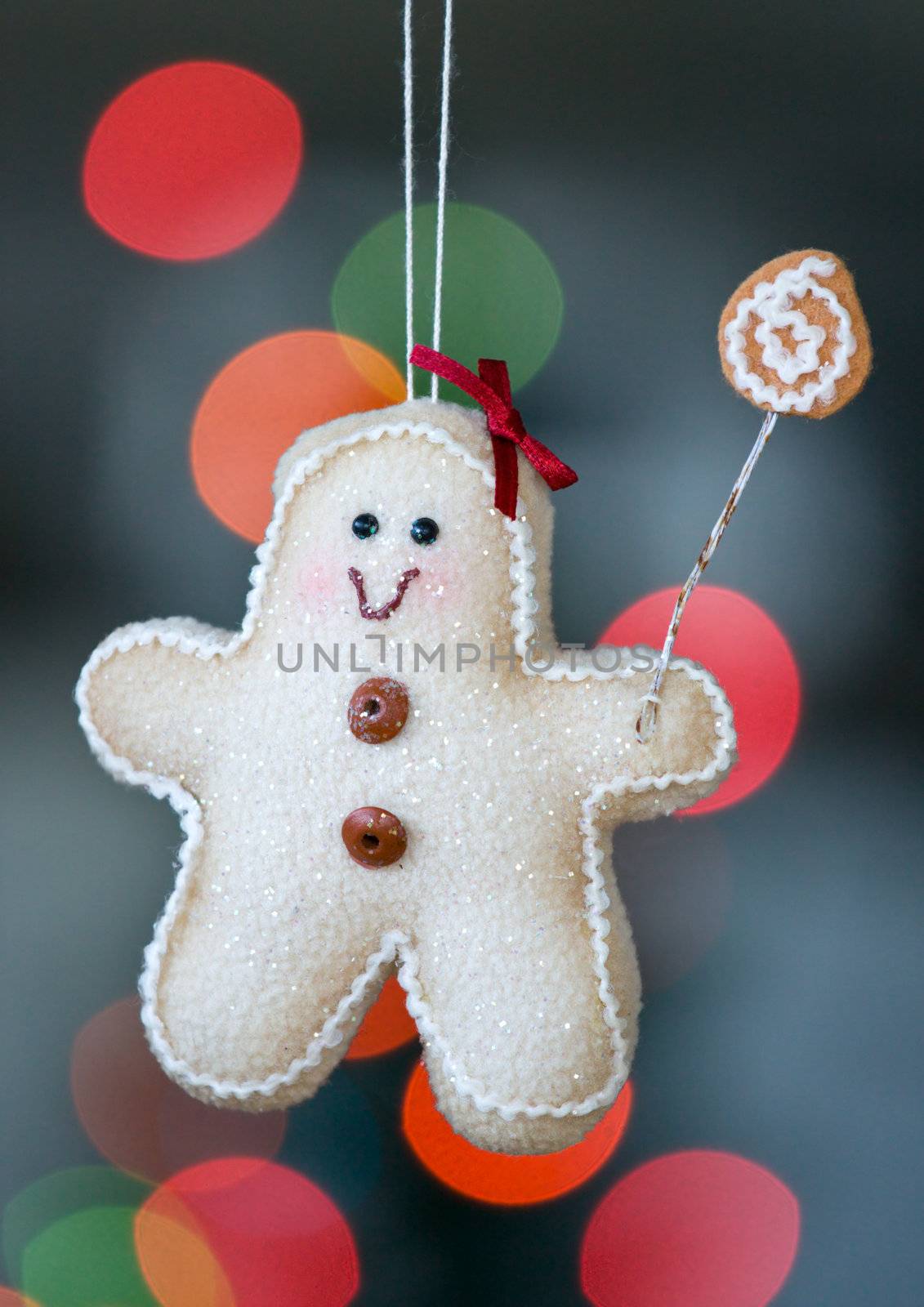 Gingerbread man decoration hangs from a christmas tree