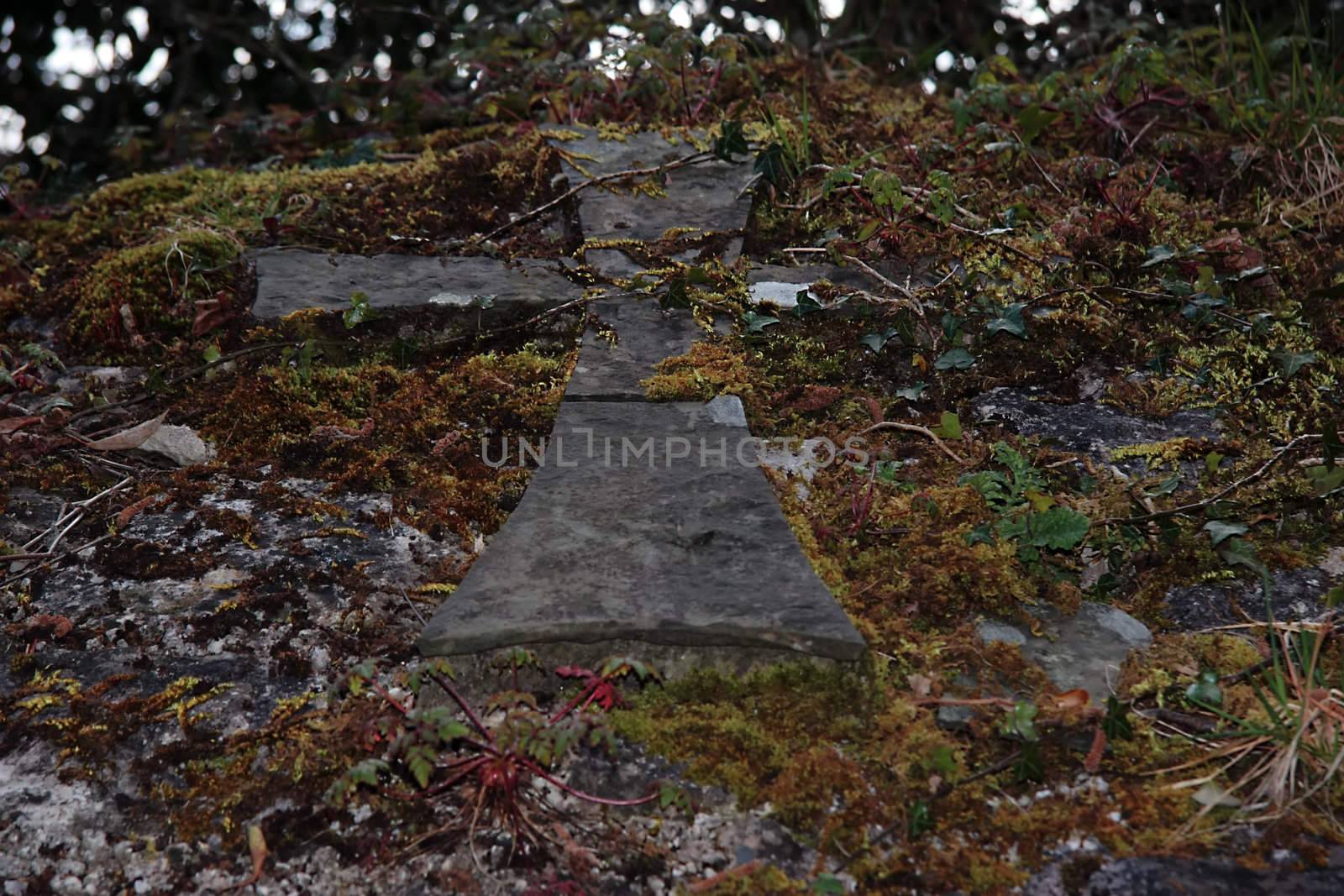 a celtic cross caved into the rock wall of a tomb