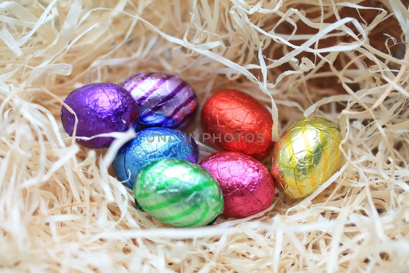 A group of colored eggs in a nest