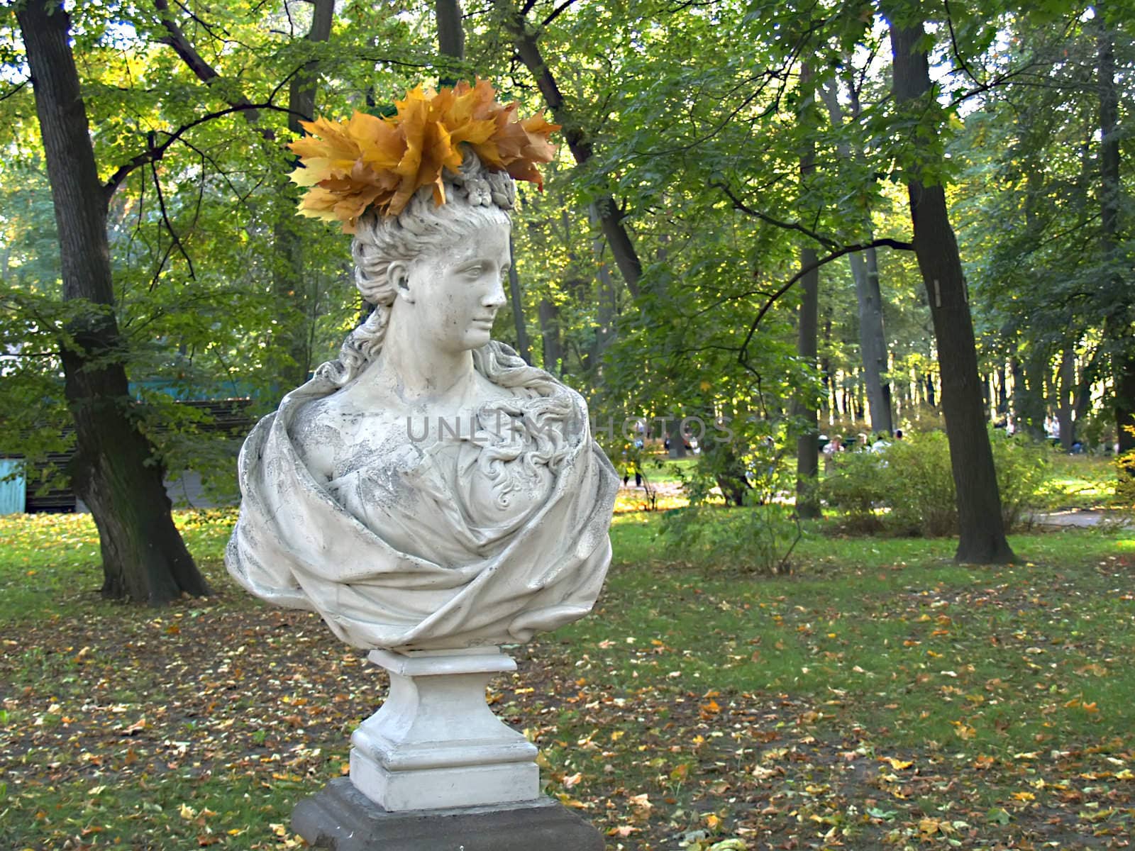 Antique sculpture with a wreath from leaves in autumn park. Summer Garden in St Petersburg Russia