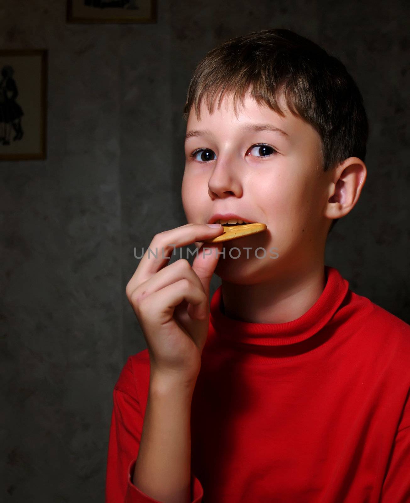 The little boy chews a cracker