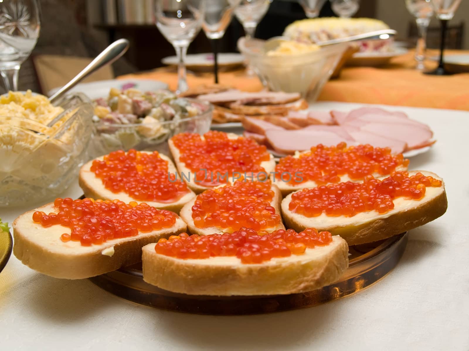 Table covered for a celebratory dinner. Sandwiches with red caviar.