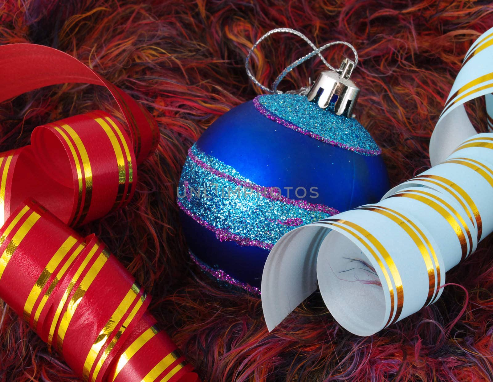 Christmas blue ball and color ribbons on a fluffy background