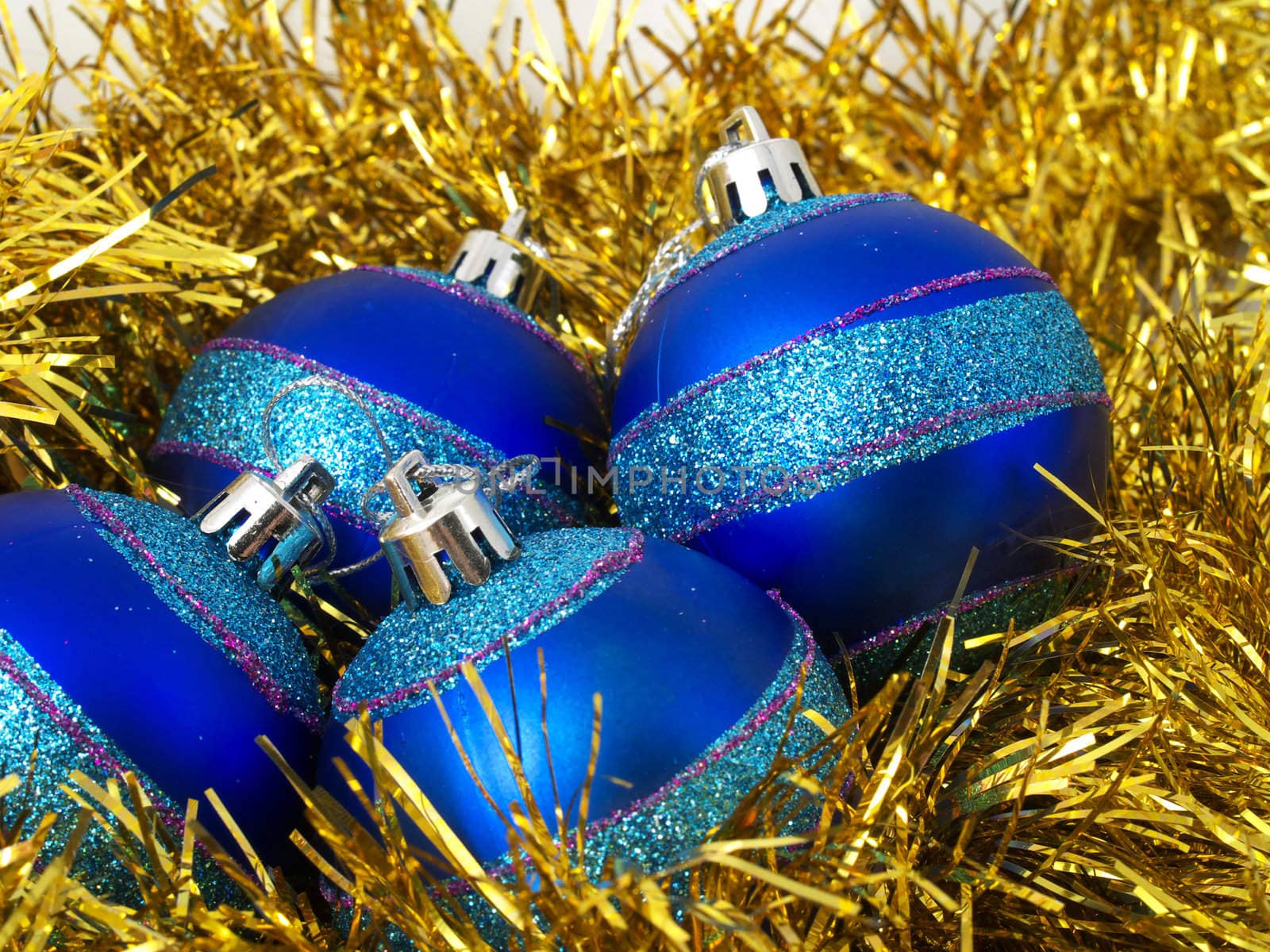 Christmas blue ornaments and gold tinsel on white background