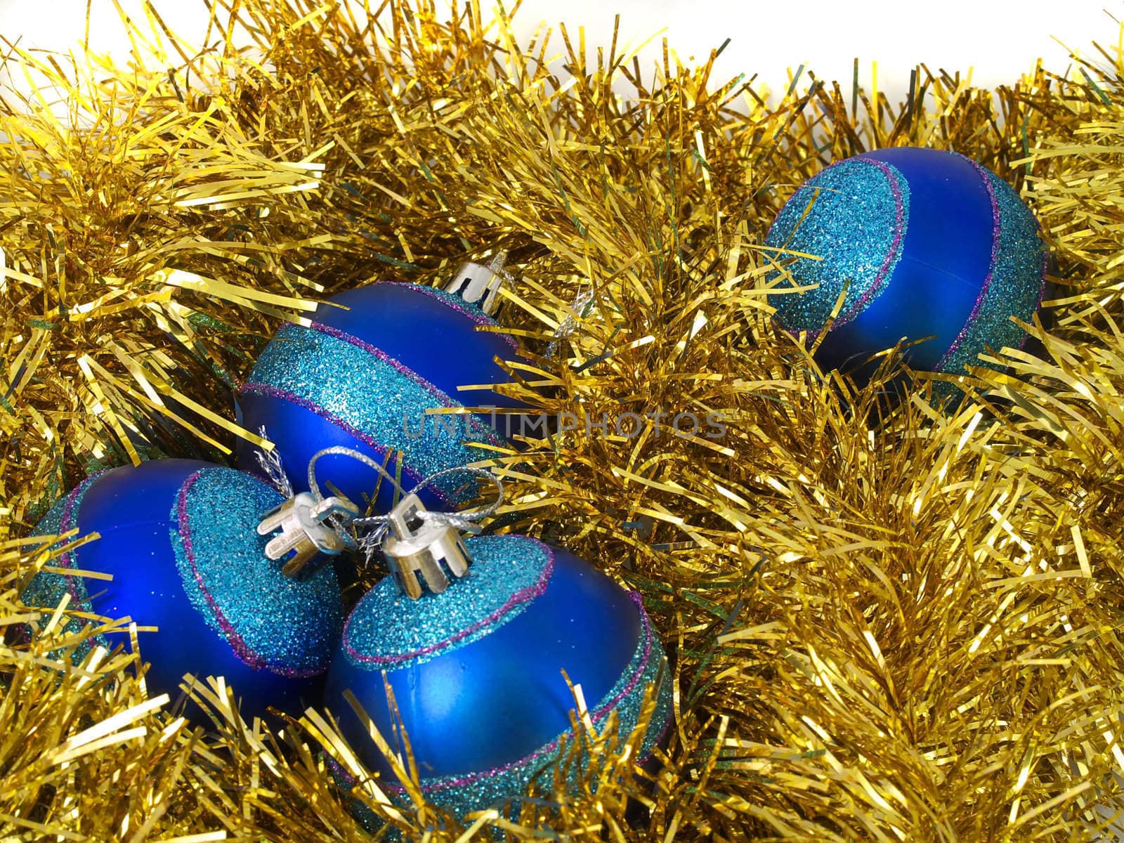 Christmas blue ornaments and gold tinsel on white background