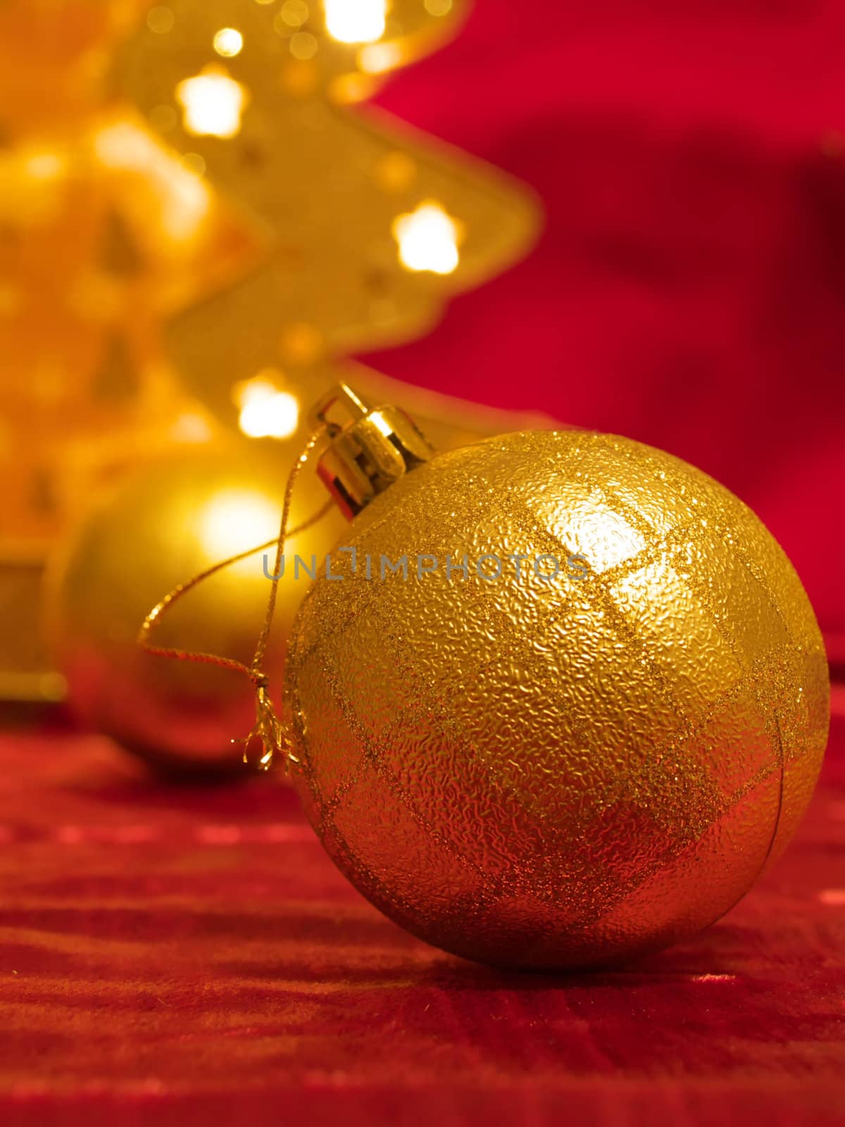 Christmas gold ornaments and gold with lamp like fir on the red background