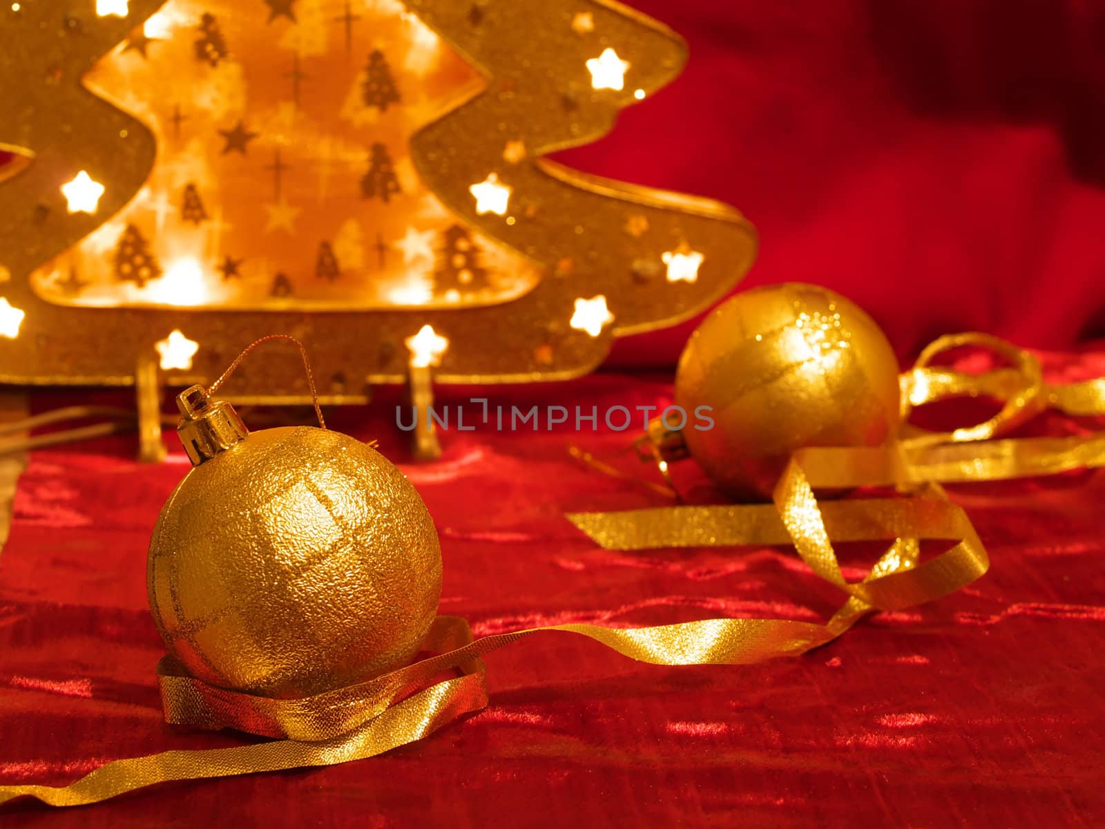 Christmas gold ornaments and gold with lamp like fir on the red background