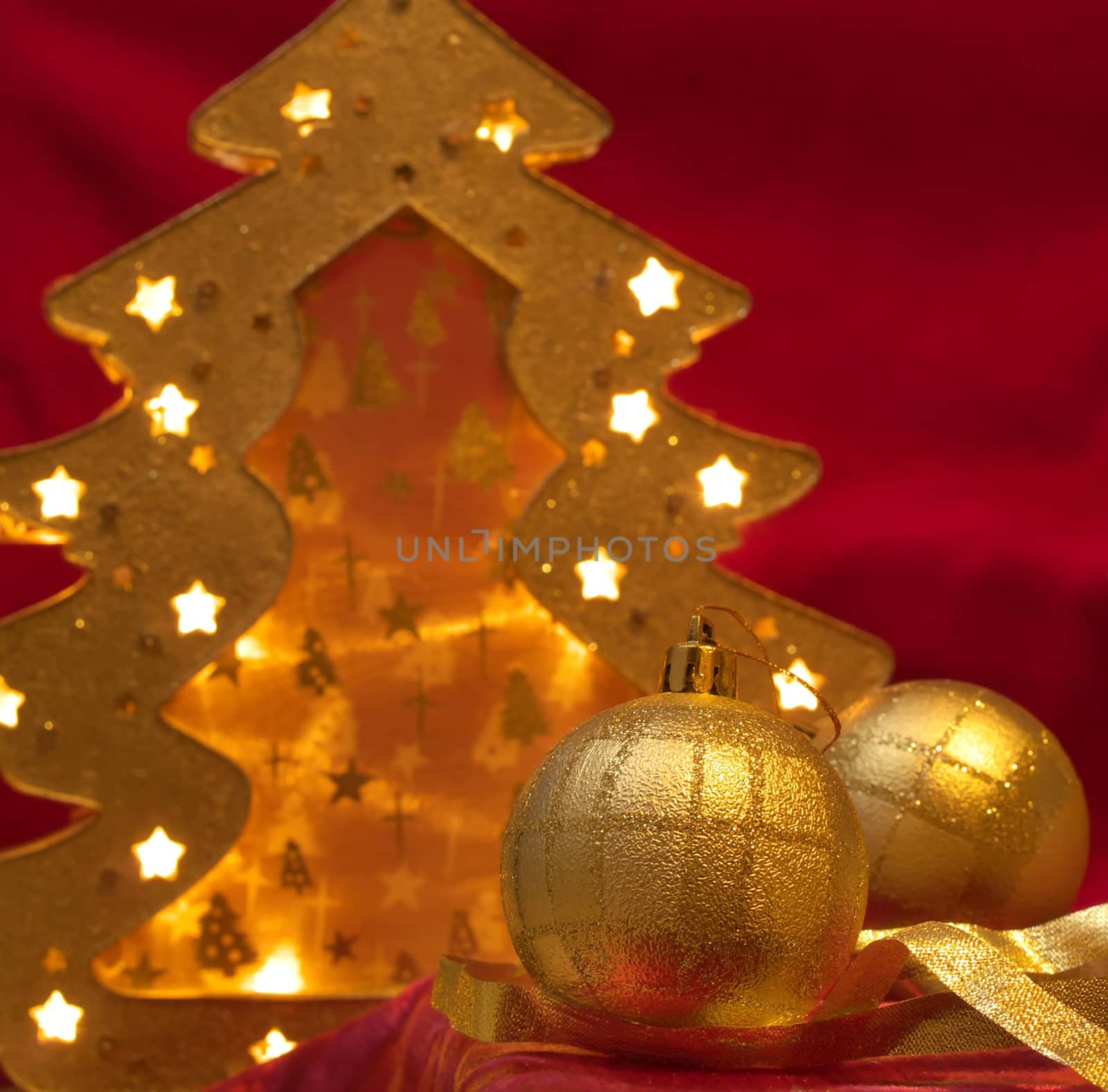 Christmas gold ornaments and gold with lamp like fir on the red background